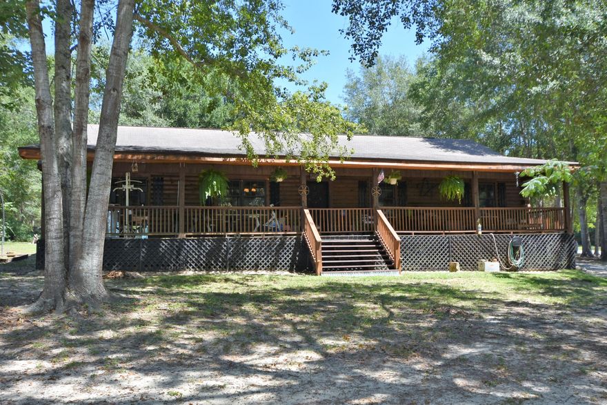 Beautiful Log Cabin on 1 Acre Fully Fenced with Workshop and HUGE Porch with a VIEW! Enjoy your home with WOOD flooring, UPDATED Bathrooms, Wood Burning Stove, Private Well, Fenced area for your animals and Much More! 4 Bedroom Home is offered with a 1 Yr Home Warranty and Closing Costs assistance....making it EASY to BUY! Welcoming Covered Front Porch runs the length of the home and is perfect for relaxing! Step in through the front door to the Living Room featuring a Wood Burning Stove. Easy to entertain with an open Kitchen and view to the Dinning and Living Room. 4th Bedroom is located off of the Living Room. Master Bedroom is located at the Back of the house with a fully updated bathroom to include: Oversized Tiled Shower, New Vanity and Fixtures! Schedule your VIEWING!