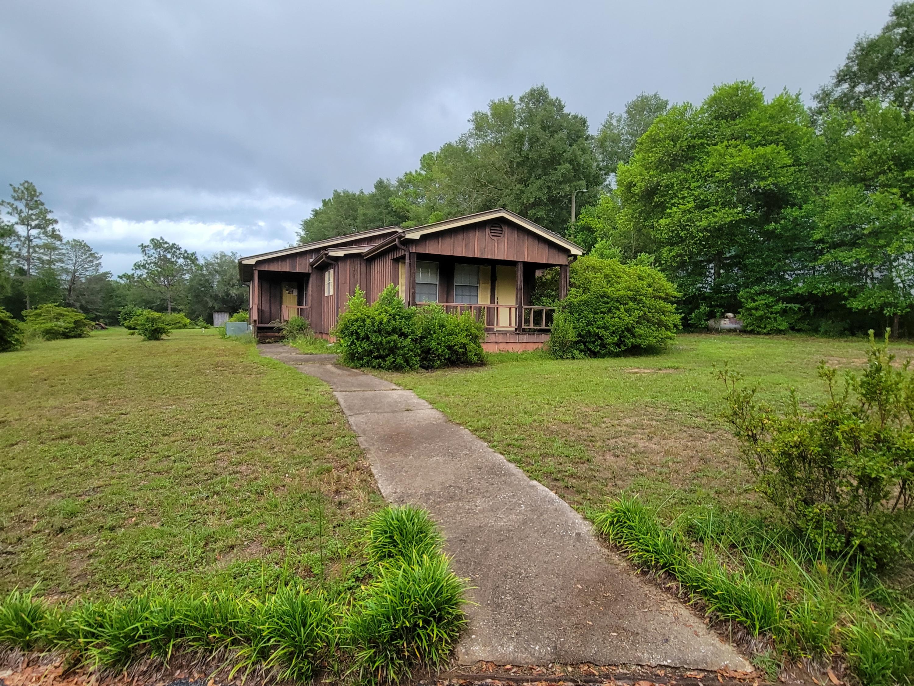 Great Location! This well kept 1982 home with 2-3+ bedrooms 2 bathrooms inside and a 3/4 bath in exterior utility room ( perfect area for a man cave...it is adjoining a double car carport. This home floor plan is not your traditional so your family's will be able configurate several different room and floor plans to fit your family's needs. Space-saver kitchen with an enormous amount of cabinets to the ceiling complete with gas stove, refrigerator. Interior walls and ceilings are Cypress paneling that give you that warm cabin flavor to this home. New septic (less than 6 months ago)