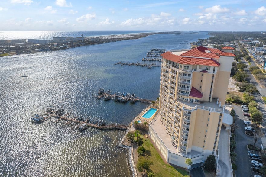 Come experience luxury living at Presidio Yacht Club, one of Fort Walton Beach's most prestigious waterfront communities! Presidio offers high-end amenities including a pool and hot tub, marina (with boat slips available for sale!), dock for fishing, theater room, owners' community lounge, fitness center overlooking the water, and a guest quarters for visitors. This beautifully updated condo offers fresh paint, new flooring, a renovated bathroom and updated kitchen, creating a home that truly shines. Step onto the expansive balcony and take in breathtaking 180-degree views of the Santa Rosa Sound, Gulf, and Choctawhatchee bay. A rare feature of this unit is two deeded parking spaces located in the gated, covered garage and a storage closet just across the hall from the front door! Inside,  the open living area boasts elegant tray ceilings and crown molding, with a wall of windows framing the gorgeous water views. The spacious kitchen is designed for both function and style, featuring abundant cabinetry, a large island with breakfast bar, pantry, updated appliances, and stylish lighting. Just off the kitchen, a dining area provides the perfect spot for everyday meals or entertaining. The split primary suite offers ample space for a sitting area and direct balcony access. Its spa-like en suite includes a jetted tub, separate walk-in shower, dual vanities, a private water closet, and a generous walk-in closet with custom wood shelving. Each guest bedroom enjoys its own en suite bathroom, both recently updated with new tile, vanities, mirrors, and lighting. One features a brand new tiled standing shower. The two guest bedrooms are thoughtfully placed at the front of the unit, each offering privacy and comfort. From sunrise to sunset, this residence delivers the perfect balance of luxury and waterfront serenity!