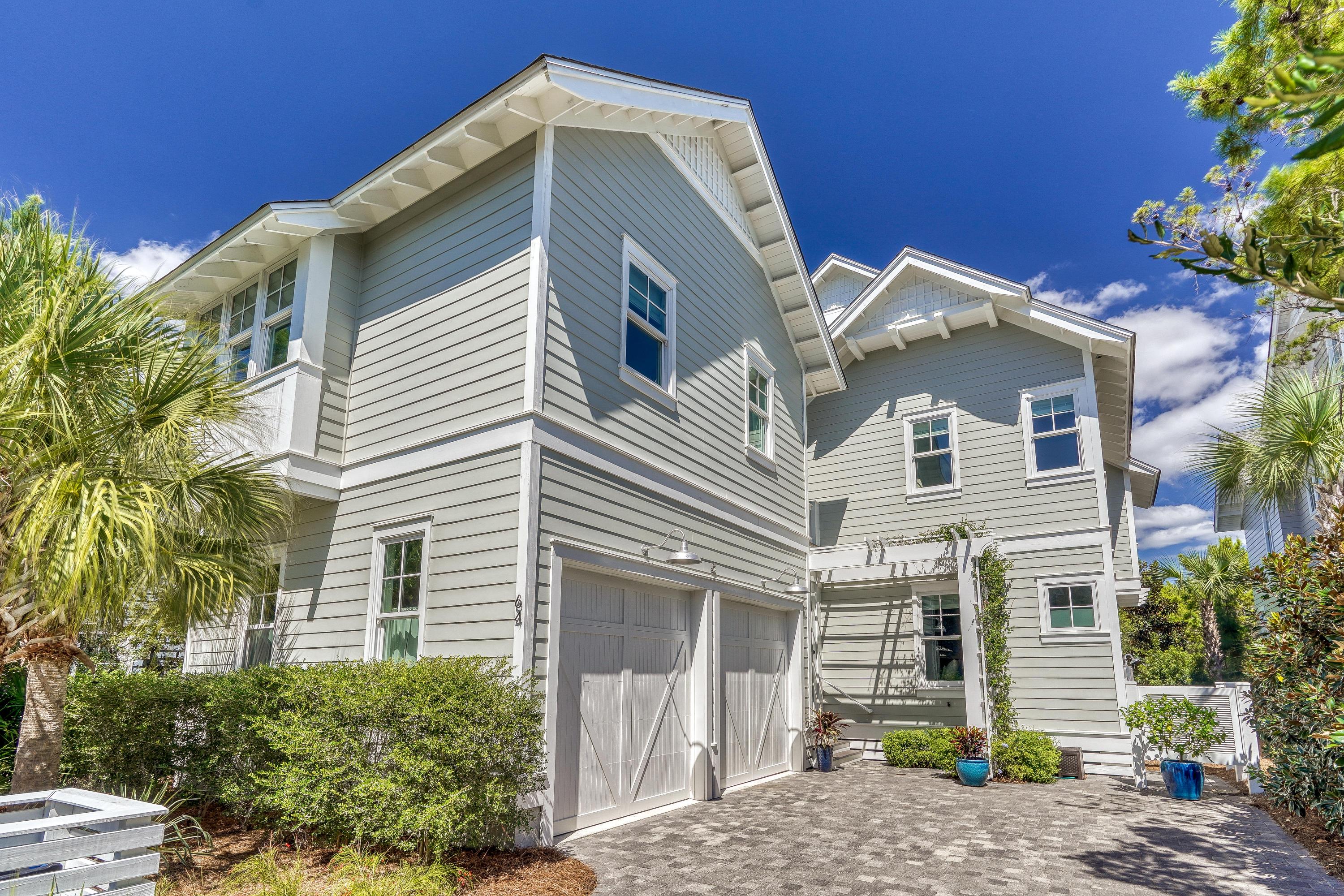 This immaculate, professionally-designed and decorated home invites comfort, and exudes modern elegance. With over 3440 sq. ft of heated and cooled space and 1750 sq. ft of screened, covered and open decks, a lap pool and two outdoor fireplaces, this home is the perfect home for entertaining or relaxing and enjoying the coastal lifestyle.Enter the home via the 450 sq. ft screened porch featuring Taby fireplace, gas logs and plenty of space to lounge, dine and watch your favorite game.The spacious living room has 10 ft ceilings, ample windows and natural light, wood beams and v-groove wood walls throughout,. Beautiful French doors lead out of the living room to the 375 sq. ft covered deck and the lap pool, blending the indoors and outdoors in perfect harmony.