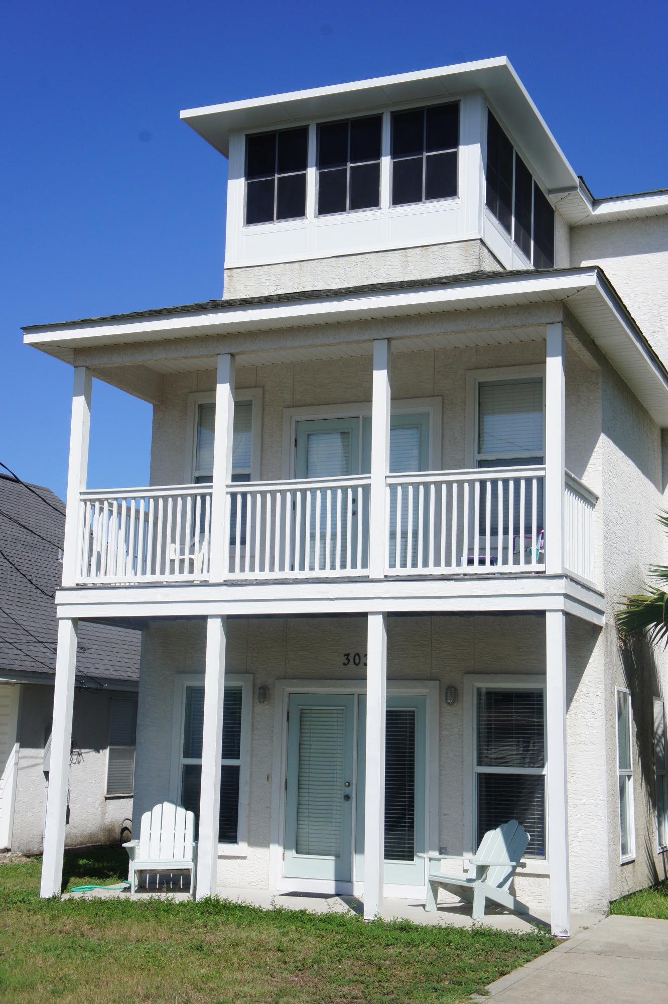 Your paradise awaits you - 303 Paridiso! A RARE FIND AND MOTIVATED SELLER! Absolutely stunning 4 Bedroom, 3 Bath home located on Panama City Beach's quiet west end with lovely gulf views from the newly constructed sunroom on the third floor. This sensational three story home encompasses all of the essential elements of Florida living - gorgeous columns grace the front of this home and greets family and guests with an open porch for entertaining, spacious bedrooms on all levels (one bedroom on first floor, two on second floor, and one on the third floor), views of the gulf, a gigantic 50x150 yard (with room for a cottage, mother-in-law quarters, or pool), and a newly constructed carport. There is electric hookup and an additional septic tank located in the back yard for a visionary buyer