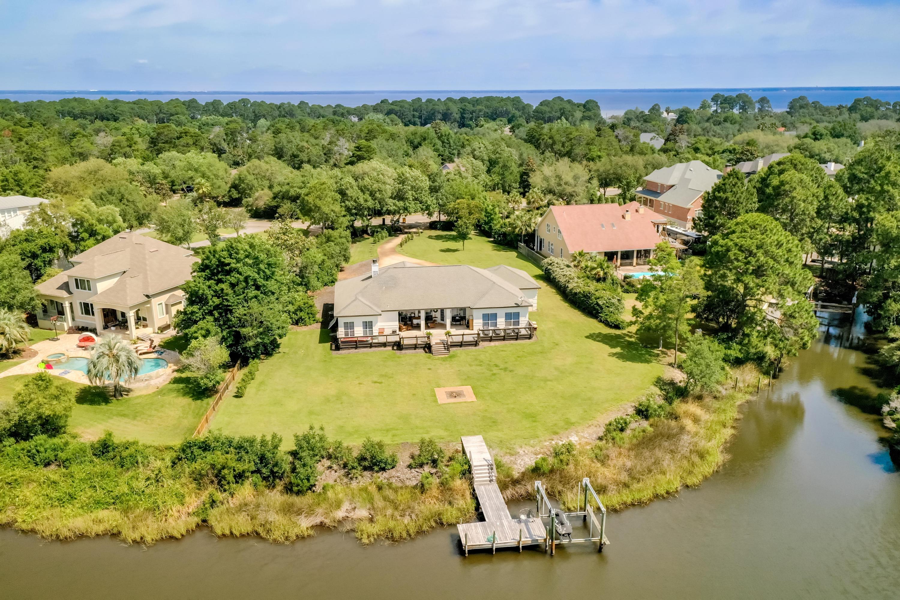This amazing home on Indian Bayou has undergone a major remodel and upgrade, transforming it from a practical residence on a desirable lot to a unique and gorgeous home that combines classic elements with contemporary conveniences. Nearly one acre on Indian Bayou, with quick access to the Choctawhatchee Bay, the property is ideal for a relaxed indoor/outdoor lifestyle that includes watersports.The home has so much to offer! The exterior features a classic and sturdy painted brick exterior, large front porch and huge sundeck out back. Inside, the huge vaulted ceilings and large windows make the home beautifully bright, while stunning plank hardwood floors add warmth. The one-story floorplan includes a huge living room that flows well into the formal dining room and kitchen