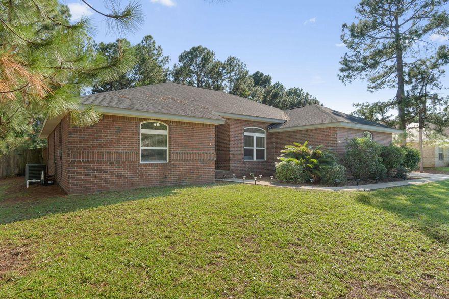 Welcome to this beautiful all-brick 3-bedroom, 2.5-bath home with a spacious split floor plan that's perfect for both entertaining and cozy nights. Upon walking in you are greeted by a spacious foyer, tile flooring in the main areas, and LVP in the bedrooms. The living room features vaulted ceilings and a fireplace for those occasional cool Florida evenings. The kitchen boasts granite countertops and freshly painted cabinets. The generous primary bedroom comes complete with tray ceilings and a master bathroom featuring a double vanity with ample counter space, a walk-in closet, a tub, and a shower.
This home also features 2 Bonus Rooms which provide many options. The first room offers a mini fridge, countertop, sink, half bath, think game room, or movie theater. The second is well suited as an office or formal dining room. 
Step outside to the screened-in back patio for enjoyable evenings. The backyard is spacious and private with a natural wood line. 
Located in the heart of Navarre, you're just minutes away from the pristine, sugar-white sandy beaches of the Emerald Coast and Hurlburt Field. In addition, you have the added benefit of being in the Holley by the Sea community, which offers an incredible multi-million-dollar recreation facility. Enjoy amenities like year-round swimming pools, a state-of-the-art workout room, tennis courts, a playground, deeded access to the sound, a dock, fishing spots, picnic pavilions, camping areas, a boat launch, and even a sauna and steam room.
