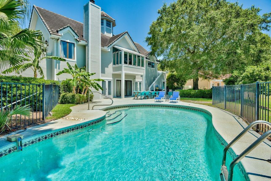 This one-of-a-kind gem features a large open great room overlooking the lake and affords effortless entertaining possibilities. Decorated in soft organic hues with a hint of a coastal retro vibe. The home is a perfect beach retreat where your family will spend the warm Florida days swimming in the pool, playing in the large fenced yard with the dog, or soaking up the sun on one of two private balconies. Sit back and unwind in the dry sauna. The kids will love sleeping in the bunk room! Four guest rooms and living area are located on the main level. A grand staircase brings you to the second story with the master suite, kitchen, dining area, and open great room with cathedral beam ceilings, fireplace, and walls of windows providing an abundance of natural light and views of the lake.