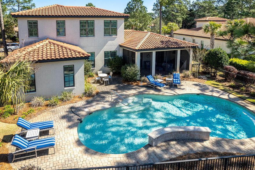 Built in 2015 by renowned Huff Builders, this Mediterranean estate boasts timeless elegance. Unwind on the screened porch with a summer kitchen or cool off in the pool. Located on #4 tee box of Baytowne Golf Course and offers views of #3 tee to green and #2 fairway and green. The chef's kitchen showcases a gas range, white cabinetry, subway tile backsplash, and a dry bar with a beverage cooler. The main level is graced by hardwood flooring and hosts the primary suite, guest suite, and powder room. The primary ensuite is a luxurious retreat, complete with a roll-in shower, double sinks, and an oversized walk-in closet featuring temperature-controlled wine storage. the second level offers a spacious living area and two additional bedrooms, each with a private bathroom.