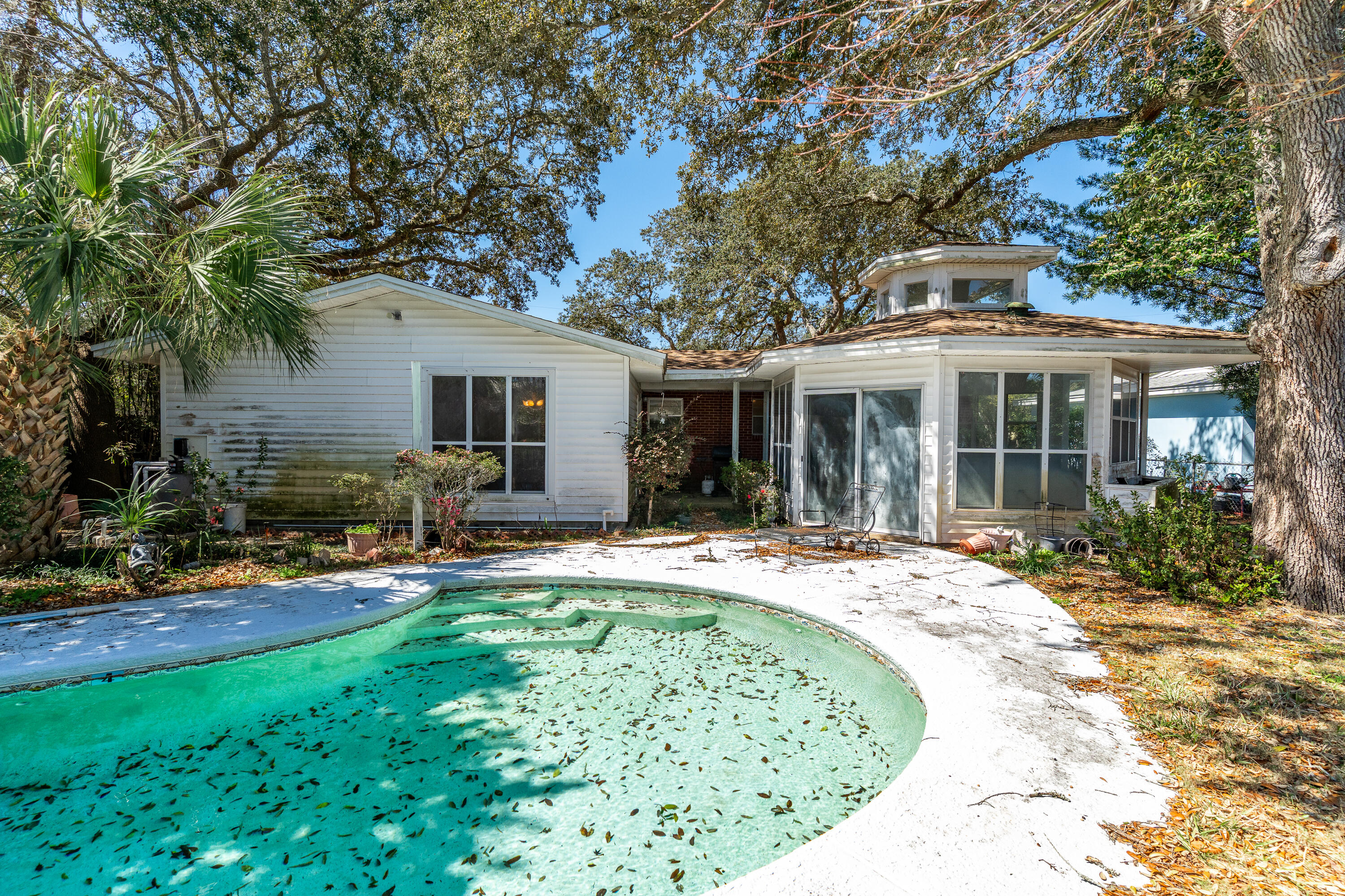 Bring your gardening tools and make this pool back yard your tropical oasis. The tiled gazebo adds character and perfect for coffee and cocktails.. The house is centrally located to all amenities; schools, dining, shopping and is less than 15 minutes to the beach and Eglin AFB. This is an 'As Is' sale and is being sold by only the second owners. A new roof was installed in 2022 and sprinkler system works.. The dining room is large enough for seasonal gatherings and overlooks the pool. One bedroom is off the dining room separate from the other bedrooms. It has a good size closet with shelving - school room, sewing/craft room maybe? With some TLC and a few repairs this will be your future cute coastal cottage to enjoy.