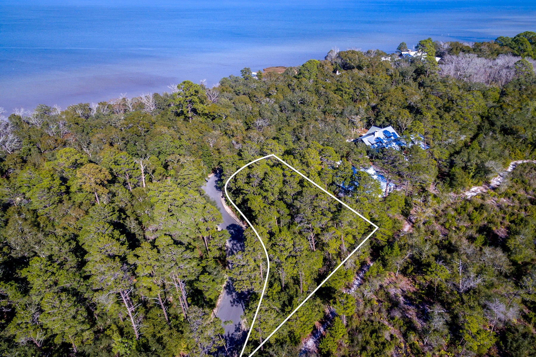Enjoy the allure of Santa Rosa Beach and Highway 30A's beach-to-bay lifestyle, The Estuary, is an exclusive gated community nestled amid towering pines, magnolias and century-old oaks on the shore of Choctawhatchee Bay. This homesite is just over one-half acre, borders the Point Washington State Forest and is next to only one other home, ensuring lasting privacy. Even the neighborhood's long entry road conveys tranquility as it journeys through over a mile of preserved nature. Enjoy this low-density neighborhood with its beautiful oak and magnolia trees and a newly finished community dock.