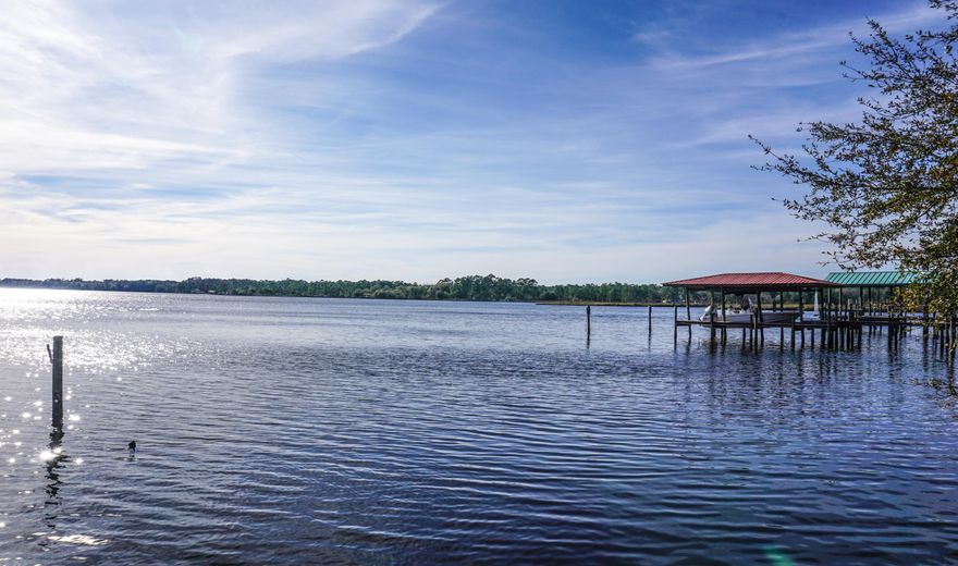 A peaceful, waterfront home with a gorgeous view and a great price! Nestled on a quiet cull de sac, this brick home is perfect for the water lover who enjoys the sound of nature. As you walk onto the land, you'll notice the Kumquat tree on the front lawn and strawberry vines on the porch; perfect for those who enjoy living off their land. Opening the door, your feet will be greeted with original hardwood floors throughout the home. Large windows bring in plenty of sunlight to keep your energy use at bay. The formal dining area is connected to the living room that has a 10 foot ceiling, allowing a substantial amount of fresh air to flow freely. The Master bedroom is tucked away down the East wing with its own large bath and shower combo plus vanity and tile floors. Walking out of the