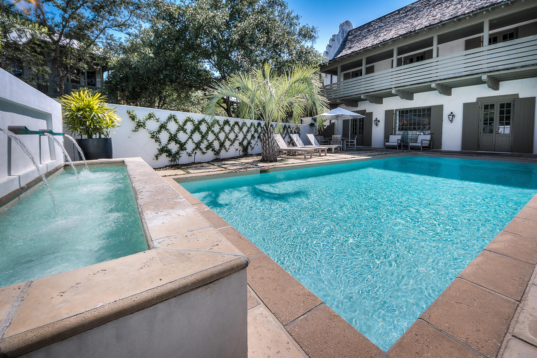 This beautiful Bobby McAlpine designed concrete home sits on one of the largest lots in Rosemary Beach. The Carriage house sits above a 2 car garage. This home also boasts one of the largest pools in Rosemary. It has an open living/dining/kitchen area on the 1st floor with a neutral color palette, shiplap walls & ceiling, vistas out to the courtyard & pool, and also has a first floor master. The breakfast bar & additional dining space are perfect to accommodate the whole family. The main kitchen features double Viking stove & range, and large island.  The additional Scullery off of the Kitchen offers ample storage, open shelving, double Sub Zero refrigerators, built in microwave & additional counter space. There is also another living space on the second floor with direct balcony access.