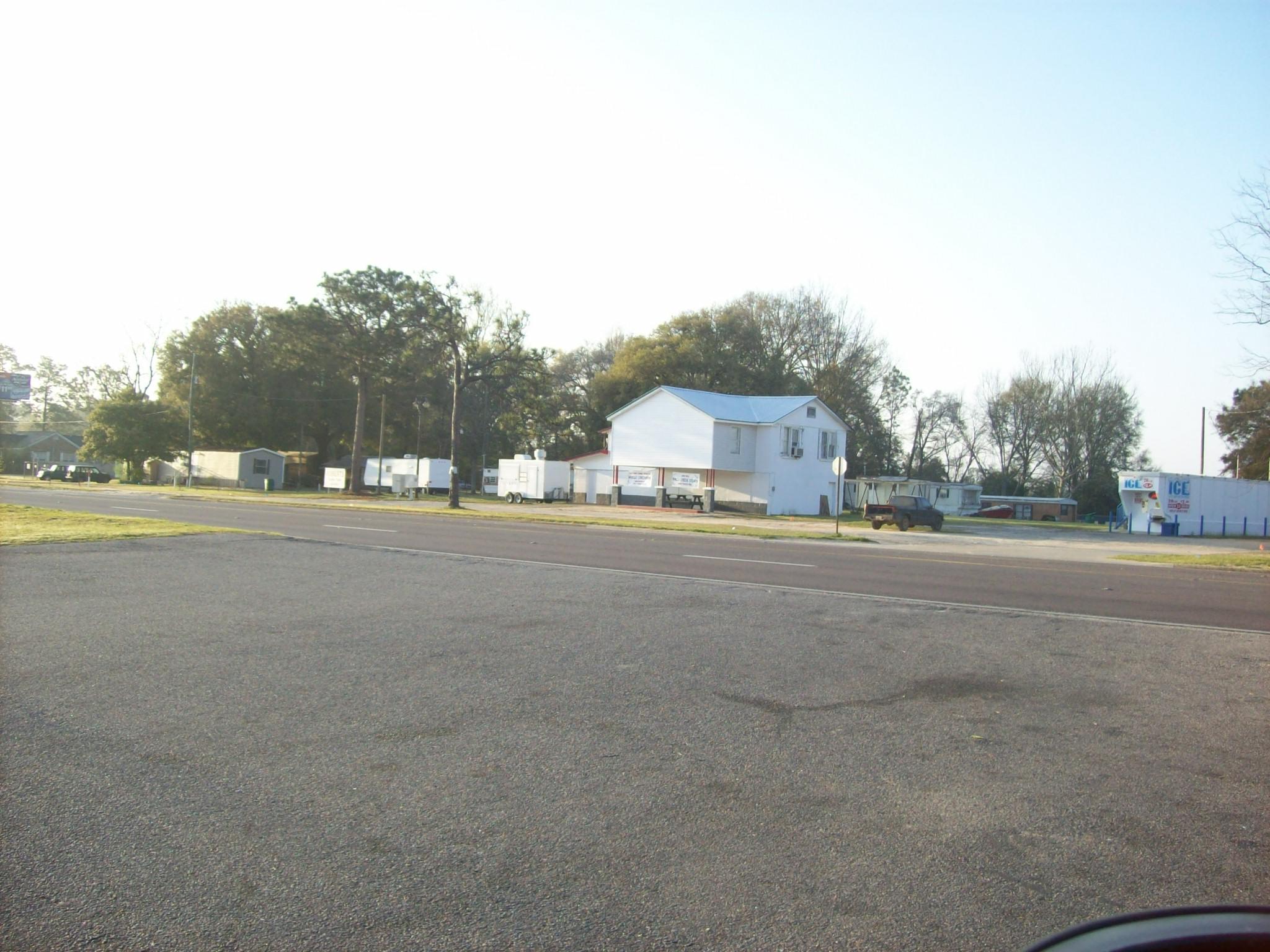2.78 acres with 400 feet of Highway frontage on Highway 90 East~ At this time there are 16 mobile home lots, there use to be 4 RV lots, there is the 2 story building that was once a Grocery Store, and a small block house~ This parcel has many possibilities , Strip Mall, Gas Station, Restaurant, Office Complex~ The property is being sold AS IS~ The lots are rented to individual mobile home owners~ All gas tanks were removed many years ago~