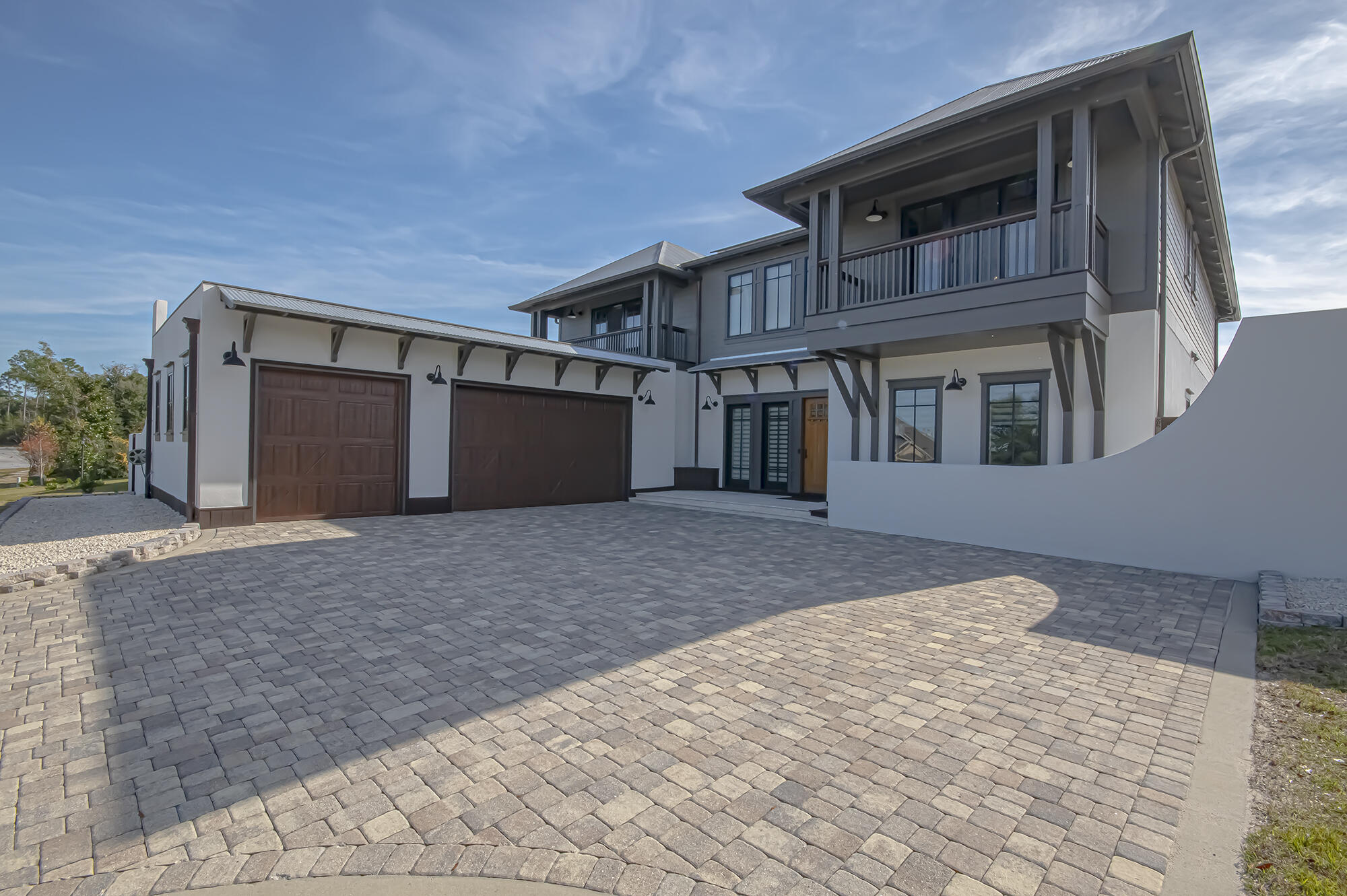 158 Lake Merial Blvd, absolutely stunning ''Montego Bay'' floorplan, modern and custom build, each of the 5 bedrooms has a private bath, in total there are 6 full baths and one-half bath. Begin at the gated entrance and manicured lawns, sidewalks and streetlamps and enter the paver driveway with side facing oversize, 3 car garage with epoxied floor, custom metal cabinets, work bench and tool hanger. Privacy fence with two fenced side yards for garden, play, custom built 300 sq ft outdoor kitchen with teak deck, heated and cooled pool bath w/ tiled shower and 2-person sauna. Quartz counters, under mount sink, Blaze refrigerator, ice maker, Napoleon Built in Outdoor Grill, Pacific Living Pizza Oven as well as a full-size fireplace, all overlooking t