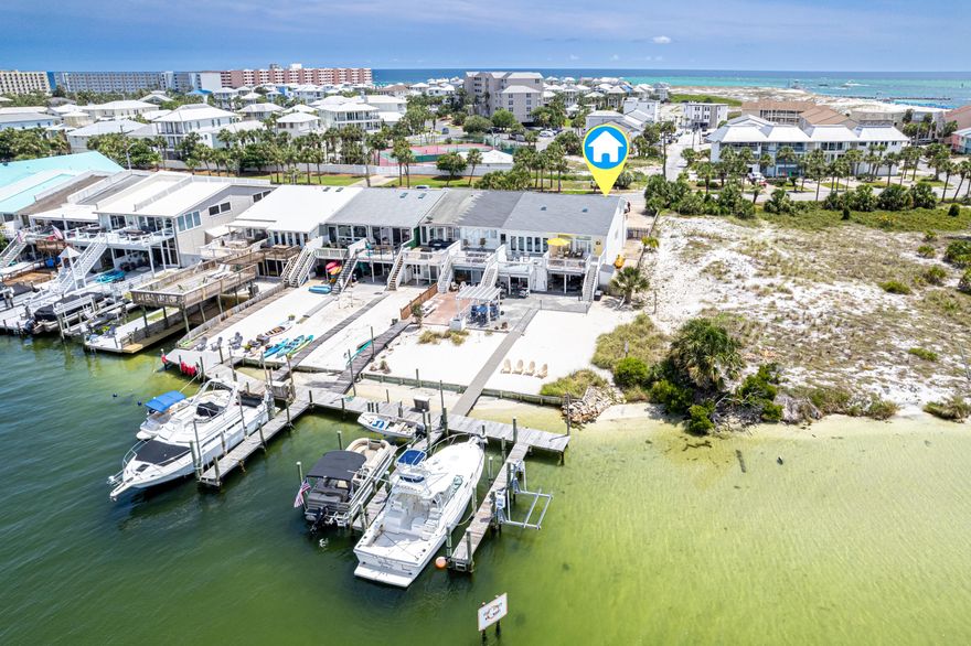 Boaters and beach lovers--this is the one you've been waiting for! Located directly on Destin Harbor, this beautifully updated 3-bedroom, 3-bath end-unit townhome features TWO deeded boat slips--including one large slip (15'5'' x 36') ideal for bigger vessels and a second slip with a lift, water, and electric hookup. Enjoy panoramic views of the harbor, the iconic Destin Bridge, and even a peek of the Gulf from three private outdoor decks. This multi-level home includes a spacious 1-car garage, granite countertops, updated bathrooms, new Hardie siding, fresh exterior paint, and new exterior doors--making it as turnkey as it is charming. The roof was replaced in 2021. It also comes fully furnished and rental-ready, perfect for vacation rental income or immediate personal enjoyment. Additional highlights include:
"	No HOA fees for the townhouse
"	Low annual $355 fee for Holiday Isle Improvement Association (covers common areas)
"	Dock was replaced in 2019
"	Double driveway and large lot with abundant parking
"	Outdoor shower for rinsing off after a beach day
"	Short walk to the O'Steen Beach access

Whether you're setting sail from your private slip or soaking in the views with your morning coffee, this is coastal living at its finest. Schedule your private showing today!
