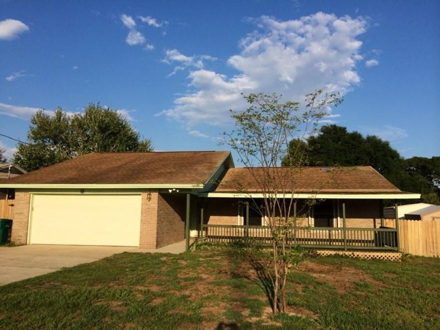 Could be featured on the TV Show ''total makeover'' Enjoy your front porch, beautiful wood floors, brand new carpeting, freshly painted house inside an out. stainless steel appliances convey. Custom hurricane shutters. updated shower, new toilets. 3 bed 2 full bath with oversized 2 car garage. brick home, with beautiful Florida room with high ceilings, new light fixtures and ceiling fans. fenced in back yard. extra large corner lot, 2 storage buildings..this house is better than new and move in ready. Home Warranty conveys!