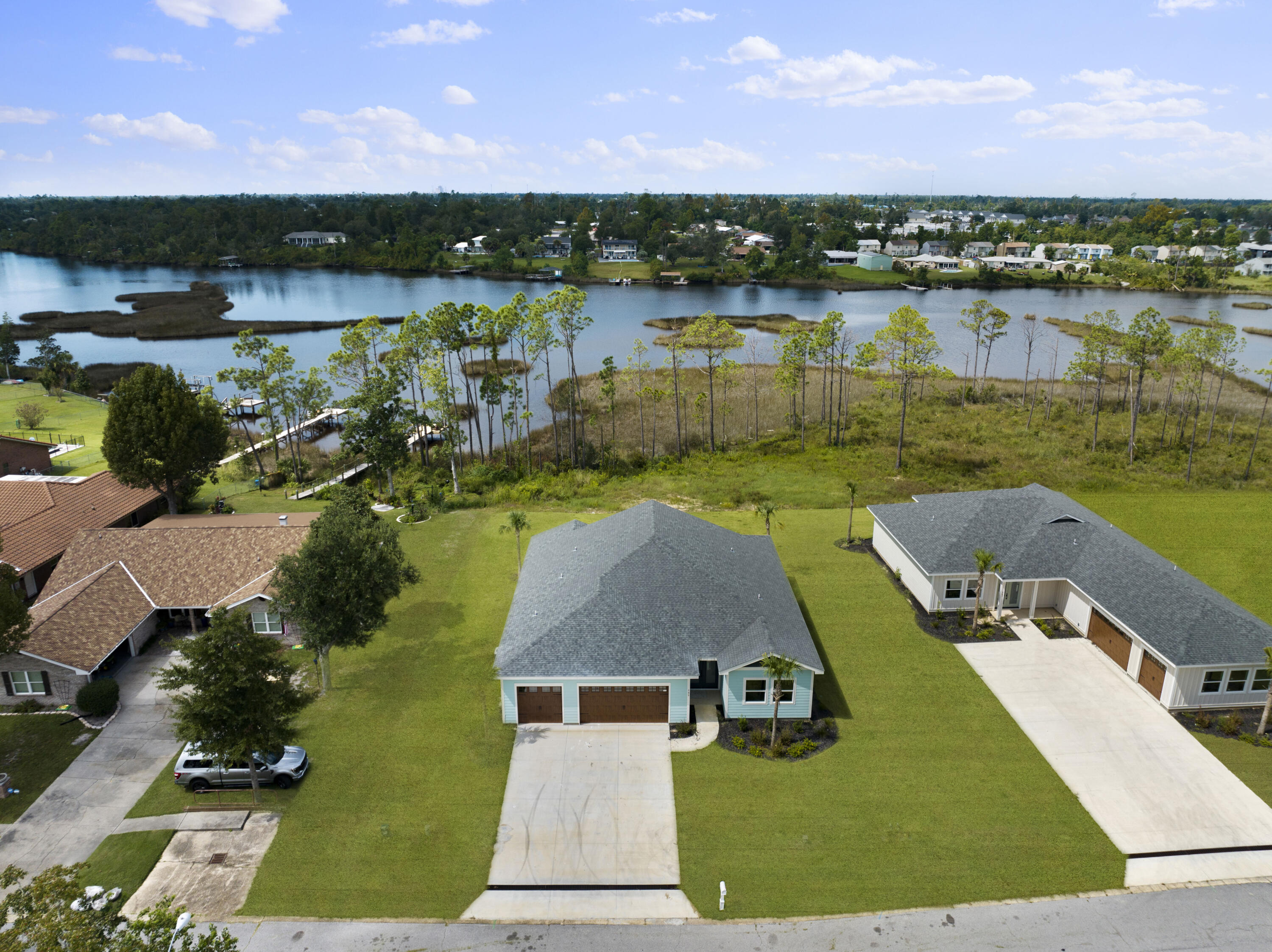 Discover your dream home located on Calloway Bayou just miles from the charm of Historic St. Andrews and downtown Panama City known for its quaint shops, dining & entertainment. This beautifully crafted NEW construction waterfront property, offering the perfect blend of modern living and tranquil waterfront beauty on nearly a half acre lot. Imagine waking up to breathtaking water views & enjoying the convenience of adding your own private dock or luxurious pool to create the ultimate outdoor oasis. Navigate Callaway Bayou all the way to East Bay & Shell Island. Enjoy true serenity and activities like fishing, paddling, kayaking & boating right from home. Don't miss this rare opportunity to own a beautifully appointed home in paradise with NO HOA! Prime location near Tyndall AFB  Interior offers beautiful architectural details like wood vaulted ceilings, incredible pocket sliders bringing the outside in and upscale state of the art kitchen. Additional features are ensuite bathrooms for every room, stainless appliances, Quartz countertops, an open floor plan ideal for entertaining and premier indoor/outdoor living with an expansive covered back porch. The lot is large enough for a pool and you can add a dock for easy access to the water. Not one but two bedrooms are waterfront and you can capture the same stunning views from the living & dining area and kitchen. The main living areas and primary bedroom features luxury vinyl flooring. The ensuite bathrooms are impressive with custom tiled showers and the primary also offers a large soaking tub to unwind in. There is a half bath off the kitchen which is ideal while entertaining. There is nice storage with the 3-car garage and plenty of parking. Don't miss out on this amazing opportunity to own an exceptional waterfront new construction home and the chance to embrace the ultimate coastal lifestyle.