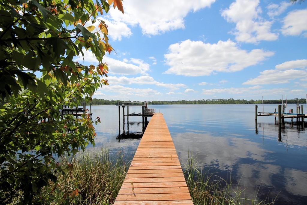 ONE OF A KIND waterfront estate home on Rocky Bayou with both an indoor pool and a carriage house!! This home was designed by Judy Diviney as her personal home and it offers many unique features a discriminating buyer will appreciate. The 1-acre lot offers plenty of privacy because of the natural wetlands that are between the home and the bayou. The home is sited on the lot so it is NOT in a flood zone and is well protected. There is a 300+ foot boardwalk extending from the back deck of the house to the natural shoreline of Rocky Bayou. At the end of the boardwalk you will find a dock with a boat lift as well as a charming gazebo overlooking Rocky Bayou. This is the perfect place to unwind at the end of the day by watching the amazing sunsets. The total heated and cooled square footage