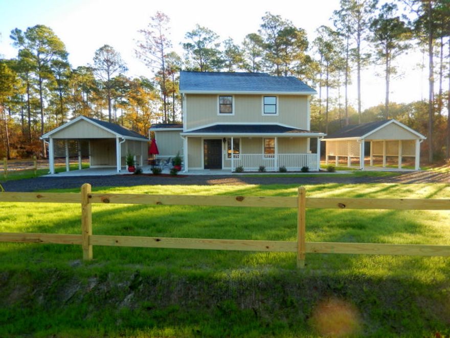 GORGEOUS, LIKE NEW HOME! A large salon with travertine floors greets you on arrival. Beautiful 3/4 inch solid Red Oak refinished floors from an old warehouse are the center of attention in the spacious 2nd floor living room,dining rm and kitchen! Granite counters, large eating bar & SS appliances accent the fantastic new kitchen. Spacious 1st floor master BR w/travertine flooring adjoins the luxurious master bathroom w/his & her sinks, vanity area & huge walk-in shower. Another spacious bedroom & bath are located on the 1st level too. The 3rd bedroom & bath & laundry room are on the 2nd level. New roof, new 1st floor HVAC & all new siding provide peace of mind. Other features include gorgeous new light & plumbing fixtures, 1/2 acre lot & TWO new carports. Spacious back deck & new