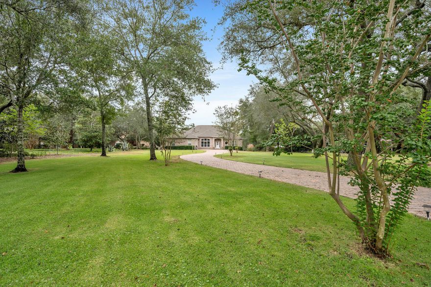 Welcome to your dream waterfront oasis! This exquisite 3-bedroom, 3-bathroom estate home boasts luxurious living in every corner and offers an impressive 2,721 sq ft of heated/cooled space with a total of 4,358 sq ft under roof. As you approach, you'll be greeted by a stunning paver driveway, framed by majestic oaks and magnolias, leading to a three-car garage. A wrought-iron fence with brick pillars fronts the property. Upon entering, you'll be captivated by the 10-foot ceilings adorned with elegant crown moldings, and the abundant natural light that filters through transom windows. The spacious living area features a built-in TV cabinet and opens up to a gourmet kitchen with granite countertops, a kitchen island, and under and over cabinet lighting. Entertaining is a breeze with a wet sink in the laundry room and an ice machine to keep your drinks chilled. Retreat to the master suite, where you'll find a double vanity, a jetted tub, and a large walk-in closet for all your storage needs. Step outside to the 600 sqft heated/cooled back porch, perfect for enjoying breathtaking water views and entertaining guests. The whole yard is equipped with an in-ground sprinkler system with a lawn pump to maintain the lush landscaping effortlessly. Boating enthusiasts will appreciate the 100 feet of water frontage, complete with a 23' boat slip and lift. A seawall ensures the safety of your waterfront investment, and storm shutters provide peace of mind during inclement weather. This home also features a partial generator, ensuring uninterrupted comfort during power outages. With an expansive 1-acre estate lot, you'll have plenty of space for outdoor activities and relaxation. Whether you're watching the sunset from your porch, enjoying the shade of the majestic oaks, or launching your boat for a day on the water, this property offers a serene and luxurious waterfront lifestyle. Don't miss the opportunity to make this stunning estate your forever home. Contact us today to schedule a private showing and experience waterfront living at its finest!