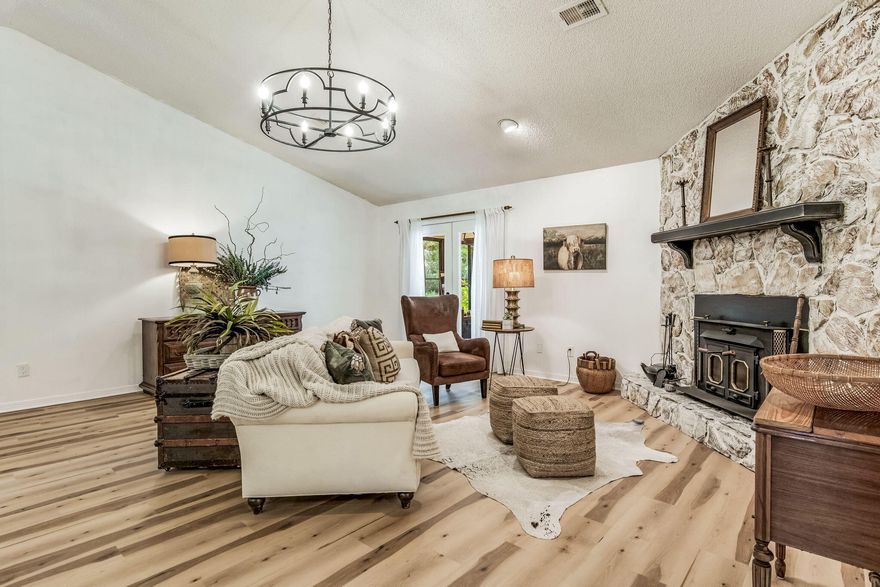 HUGE $20K+ Price Reduction!  This truly is country living at it's finest! Zoned Rural Residential (RR) and situated on a lovely landscaped 2-acre lot, this spacious, split floor plan, 3-bedroom, 2-bathroom home seamlessly combines rustic charm in an organic farmhouse style, offering a perfect retreat for those seeking a peaceful lifestyle. Step inside to discover soaring Ceilings in the Great room, a freshly painted interior and new LVP flooring that flows throughout the whole home, along with Cypress and Cedar accents. The inviting sunroom is the perfect spot to relax and soak in the natural light, overlooking the flowers & trees in the pretty back yard; or curl up on the sofa in front of the newly whitewashed, river rock fireplace with it's wood burning stove,