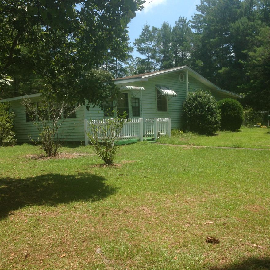 This Florida Cottage is just what you've been looking for. Three bedrooms, living room and a TV room right off the kitchen. There's a 1/2 bath off the bedroom in the back of the house. Kitchen has stainless steel double sink and oak cabinets. Fridge has bottom freezer for easy access to food. Full bath includes a walk-in bath with jets which makes it handicapped accessible. Beyond the back bedroom is a nice screened in Florida room overlooking the 24' above ground pool. Out back is a work shop and carport. Plus there is another outbuilding. All this sits on one acre. A nice place to call home!!!