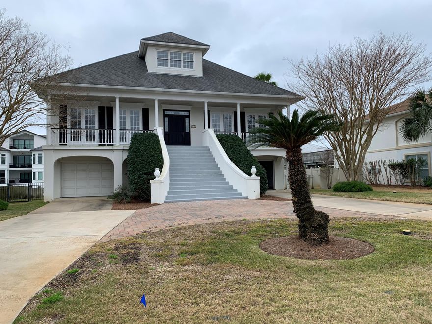 Beautiful Holiday Isle two story home with 80 ft of dock for your boating pleasure.  Home is in immaculate condition. 2nd story has Master Bedroom, Formal dining room, Kitchen with kitchen Isle, and main living room that has built in book shelves and a working fireplace. Master Bath has a Jacuzzi style tub and a large walk-in closet. First floor has 2 one car garages, 3 bedrooms and small living room . Well Landscaped.