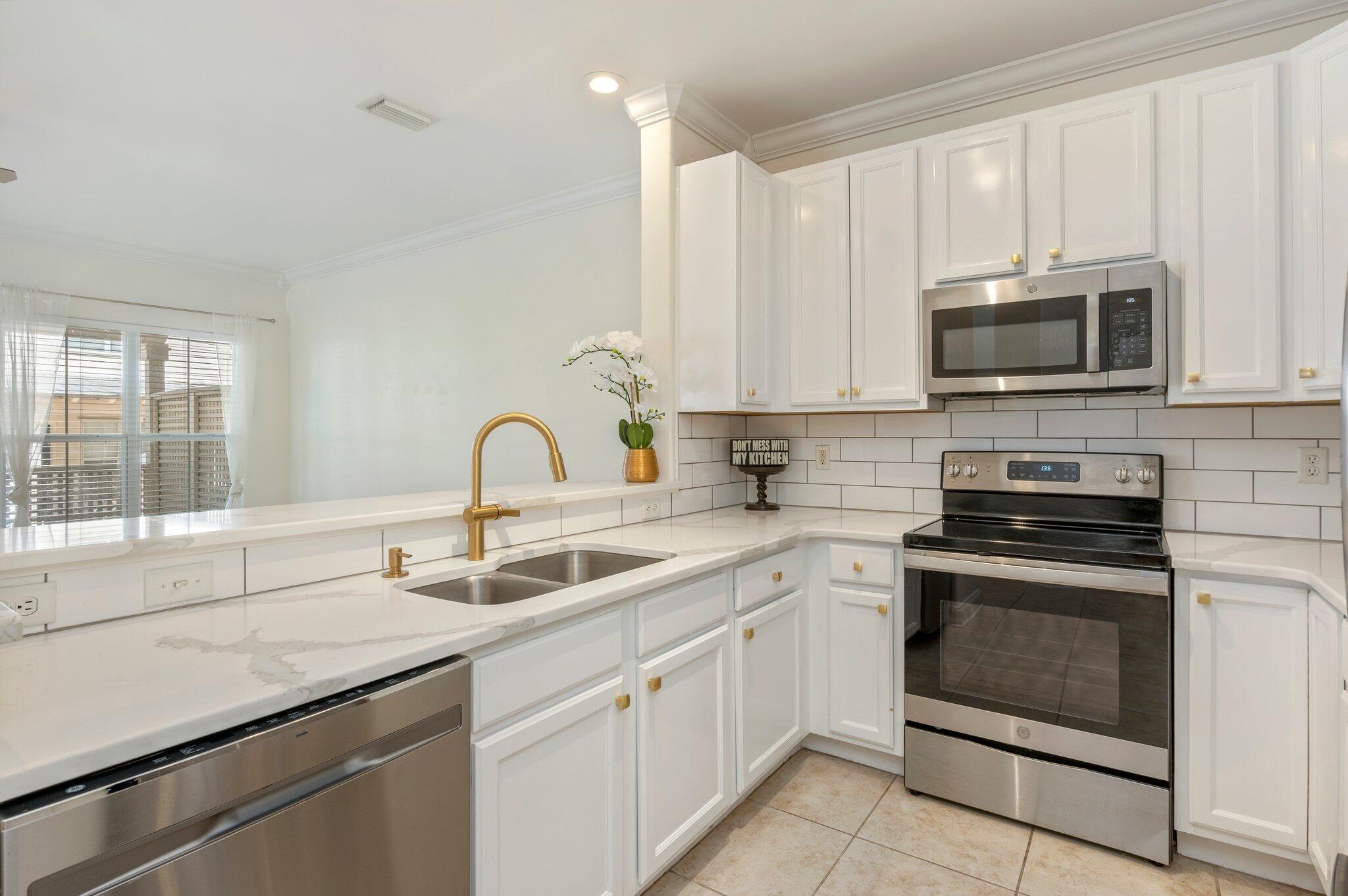 This end unit townhome offers a perfect blend of modern luxury and coastal charm. As you step inside, you'll be greeted by an updated kitchen featuring white quartz countertops, sleek stainless steel appliances, and a spacious layout that's perfect for entertaining. The tile flooring throughout the first floor adds elegance and durability, while the high ceilings and abundant natural light create an inviting atmosphere.This townhome boasts 3 bedrooms, 2 full bathrooms, and one half bath downstairs, providing ample space for comfortable living. The master suite is a true retreat with its own private bathroom and plenty of closet space.