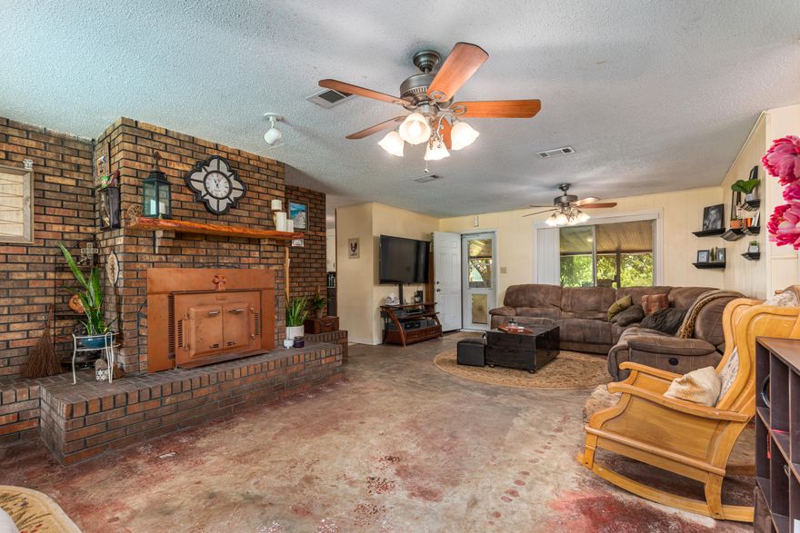 This METAL ROOFED, SECLUDED COUNTRY OASIS home offers a generous amount of space, both indoors and out.  The PRIVATE gravel driveway opens to a large, front yard with a CIRCULAR DRIVEWAY.  Here, you are able to enjoy PECAN TREES, a TIRE SWING hanging from a mature Oak tree, a WISTERIA covered seating area and a FIREPIT.  Enjoy the rain or evening peace and STARGAZING on the south facing, covered front porch.Once you enter the front door, the Majestic Brick fireplace with BLACK BART WOOD BURNING INSERT and living room will welcome you.  During the winter season, the location of the ceiling fans and intake in the hallway maximizes the fireplace produced heat to be carried throughout, heating the home comfortably.