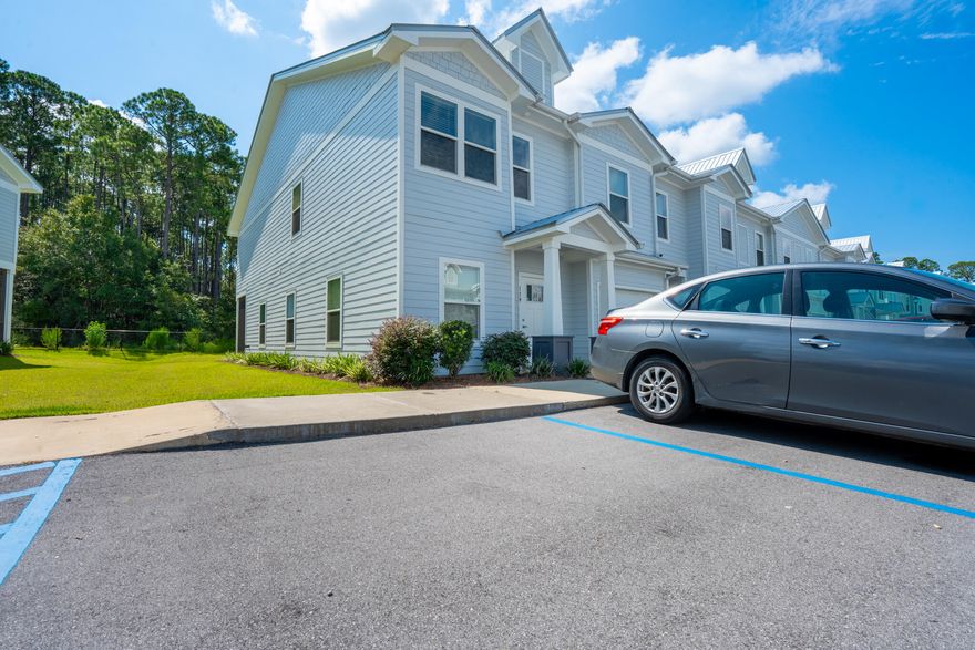 Premium end-unit townhome located in The Verandas at Freeport, offering abundant natural light and a spacious lot with wooded views for added backyard privacy. This 3-bedroom, 2.5-bathroom home features luxury plank flooring throughout, 9-foot ceilings, and an open-concept layout that flows seamlessly between the living room, kitchen, and screened back patio. The kitchen is equipped with white cabinetry, quartz countertops, a tile backsplash, stainless steel appliances, and a large island with a farmhouse sink. The primary suite includes a spacious bathroom with dual vanities, quartz countertops, white cabinetry, and a tiled walk-in shower. The guest bathroom features a single vanity, quartz countertop, white cabinetry, and a tub. Located in a desirable area within the community, resident