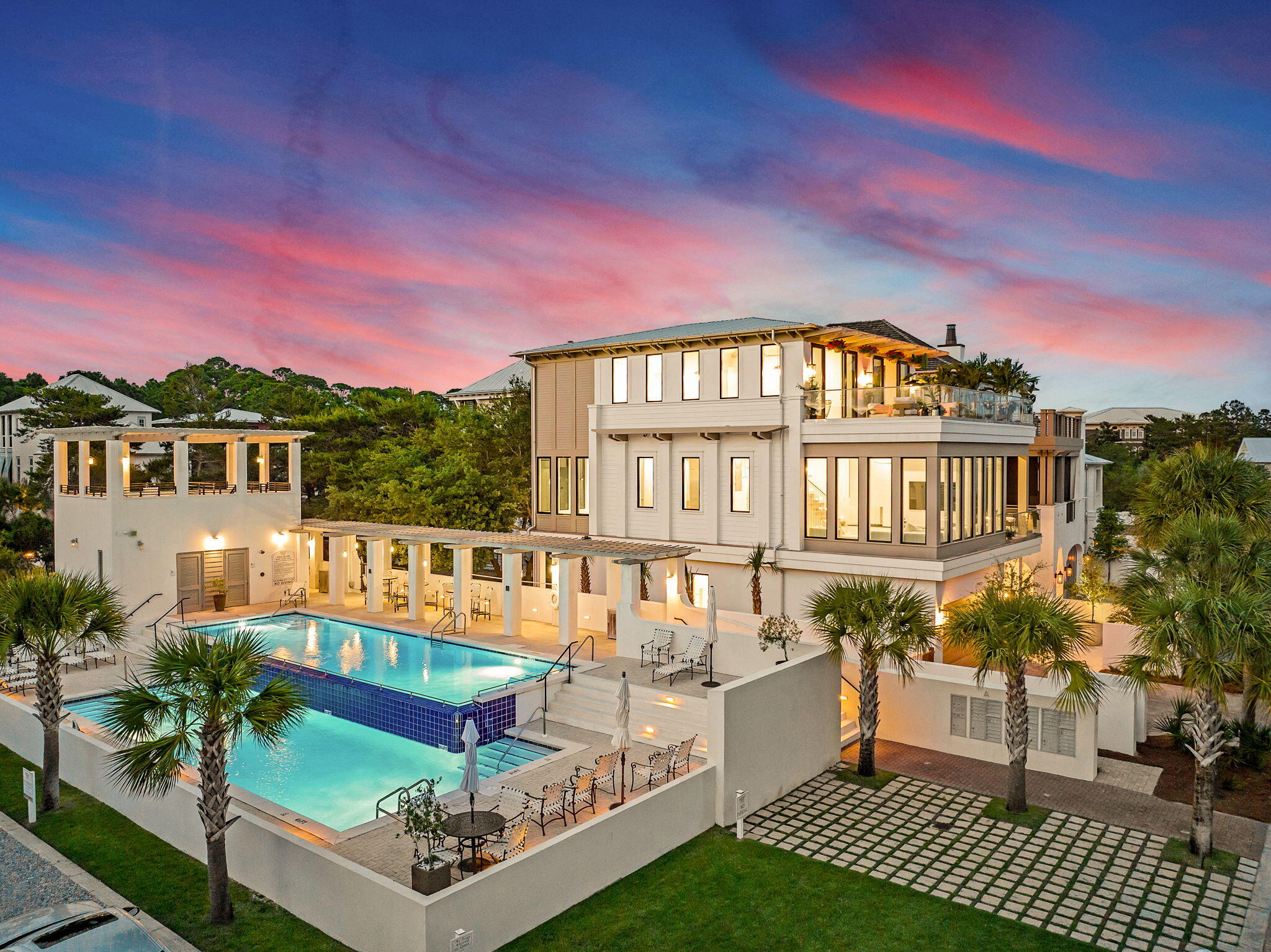 Introducing The Glass House, a stunning new construction in Seanest Village, a private gated community in the heart of Seagrove Beach. Completed in May 2025, this architectural masterpiece was thoughtfully designed by Gregory Jazayeri (GDJ Design) and Ivana Jazayeri (IVA Design) to offer a timeless, low-maintenance retreat suitable for both vacation living and primary residency.Built to last with concrete block construction on the first floor, this 3-story, 3,967 sq. ft. terrace home features:5 Bedrooms, 5.5 Baths,3 spacious living areas, one on each floor.Double primary suites, ideal for families or guests.10' ceilings on 1st & 3rd floor and almost 12' ceilings on the main living level.Large rooftop terrace with Gulf views. The residence is equipped with a state-of-the-art audio-visual system, highlighted by an 85-inch display, immersive surround sound, and whole-home WIFI and Alexa integration across all three levels. Exterior cameras provide comprehensive security coverage. Custom white oak cabinetry is thoughtfully integrated throughout. The Thermador and Viking appliances, Kohler plumbing fixtures, smart bidet toilets in the primary, junior, and powder bathroom reflect modern comfort and luxury. This home is offered furnished with a collection of stylish, modern furniture, creating a sleek and contemporary atmosphere perfect for move-in ready living.
From the private courtyard, step through a custom glass pivot door into a gracious foyer. The first floor offers one guest bedrooms and one bunkroom with 2 queen over twin bunks, two full bathrooms, a sitting area with wet bar, and a shaded porch with direct access to the Seanest boardwalk and pool.
On the second floor, an open yet well-defined plan centers around a state-of-the-art peninsula fireplace, creating a seamless connection between the living room, kitchen, and dining area. Walls of glass frame tranquil views of the pool. Culinary features include a chef's kitchen with Thermador appliances and 48" Viking gas range, a hidden oversized butler's pantry and a glass wine room display that stores up to 66 bottles. A junior primary suite, main laundry room, powder bath, and outdoor grilling porch complete this level.
Ascend the floating custom staircase to the third floor, where Gulf views greet you from the third living space and adjoining morning bar. The primary suite is a sanctuary, boasting a glass display walk-in closet and a spa-inspired bath with a freestanding tub, large double shower, and double vanity. This floor also includes a second laundry area and an additional bedroom and bathroom nestled in the canopy of live oaks.
Seanest Village offers double swimming pool with vanishing edge, deeded beach access, direct entry to the adjacent State Forest, and is just a short walk from dining, shopping, and the emerging Greenway Station.