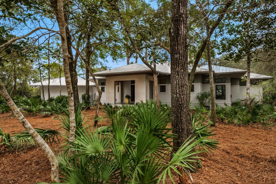 Moored behind acres of never-to-be-developed state forest awaits a home showcasing contemporary living in an elegant bay-front gated community called The Estuary. The neighborhood is approximately 10.5 feet above sea level, with lush indigenous vegetation exuding nature's inspiration throughout this intimate community of only 39 homesites. Minutes away from the blue-green waters and white sandy beaches of 30-A and Grayton Beach, The Estuary is a treasured haven. 176 Ansley Forest Drive is an exquisite one-level, three-bedroom/two-bath residence on a quiet cul de sac across the street from the bay and community dock, where enjoying beautiful sunsets with expansive bay views will become a daily ritual. This quaint masonry style (ICF constructed) contemporary gem timelessly reflects the perfect harmony between clean lines, modern simplicity, and a daily connection with nature. The sublime screened-in porch offers enhanced privacy given the conservation easement and is usable year-round. The adjacent exterior deck is delightful for outdoor dining and relaxing by the fire pit in the cooler winter months. There is a detached wood-paneled two-car garage with covered steps to the main house. The home's interior boasts Brazilian walnut flooring throughout, a vaulted great room ceiling, a wood-burning fireplace, and a modern kitchen with a gas range, stainless steel appliances, granite countertops, and custom cabinetry. The open floor plan creates an effortless flow that beautifully maximizes the use of space, while French doors leading to the exterior porch infuse the interior with the serenity of indoor/outdoor living. The master suite is cradled against an exuberant woodland backdrop making it a cozy retreat. The ensuite features his and her vanities, a custom-built walk-in closet, and a glass-front zero-entry walk-in shower. Masterfully crafted 8-foot doors grace the adjacent bedrooms and hallway. Take this rare opportunity to call this property home.