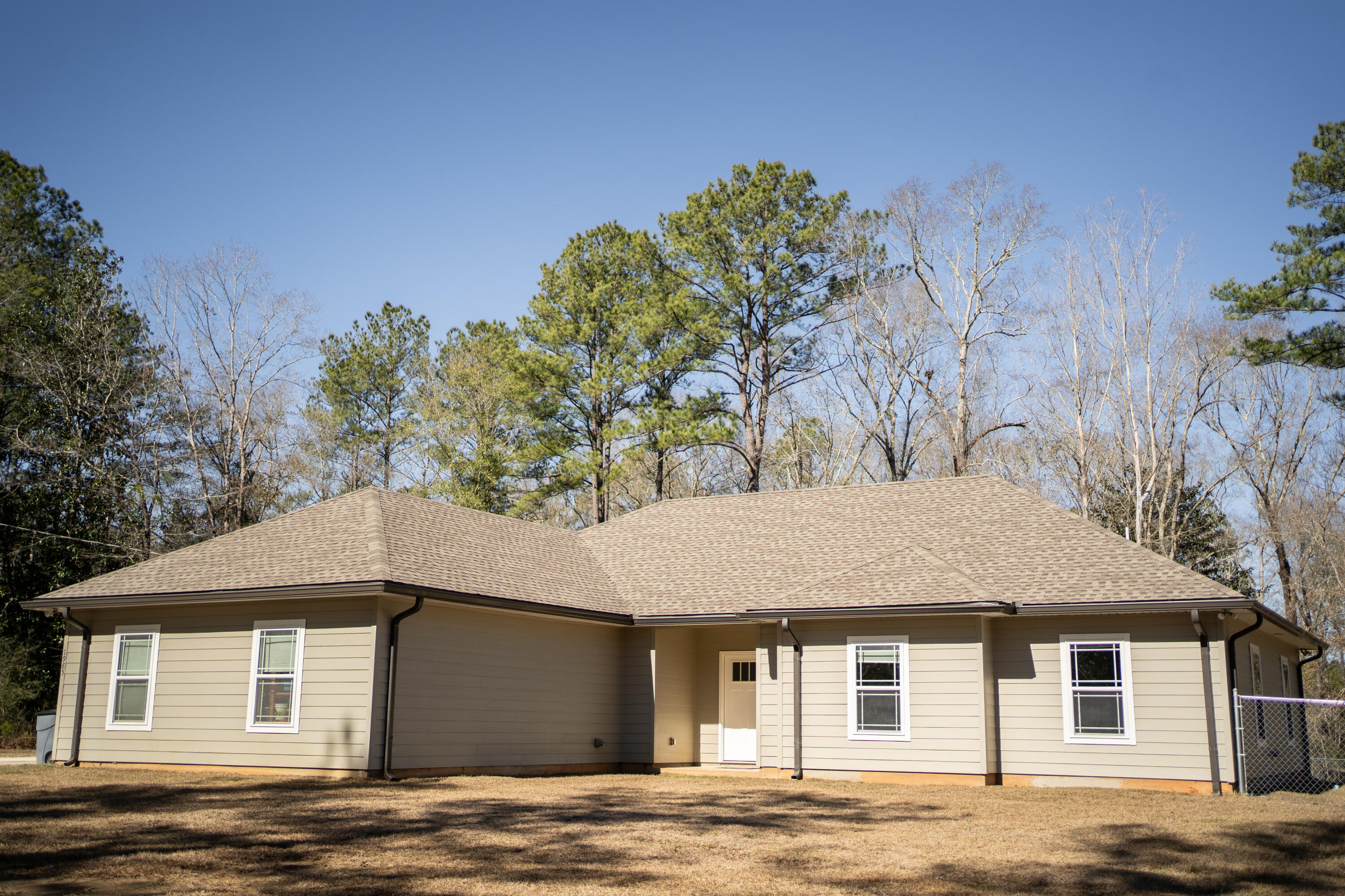 Looking for a beautiful country getaway in Baker? Look no further than this lovely home. You will be surrounded by many mature trees as you turn down the gated private drive leading to the two car garage. Built in 2019, this beautiful home sits on just over nine acres with four bedrooms and two baths. The open concept promotes a great flow from kitchen to living room for entertaining. All cabinets are soft-close. The vaulted ceilings in the living room really make the space come alive. There is LVP throughout the house with the exception of the bedrooms, which have carpet. The master bedroom and bath are very spacious and inviting. The master bath has a large garden tub with a separate walk-in tile and marble shower. The master bath also has double vanities with two walk-in closets. From the beautiful house to the large lot this property has it all! Call today to schedule your private showing before this one is gone.