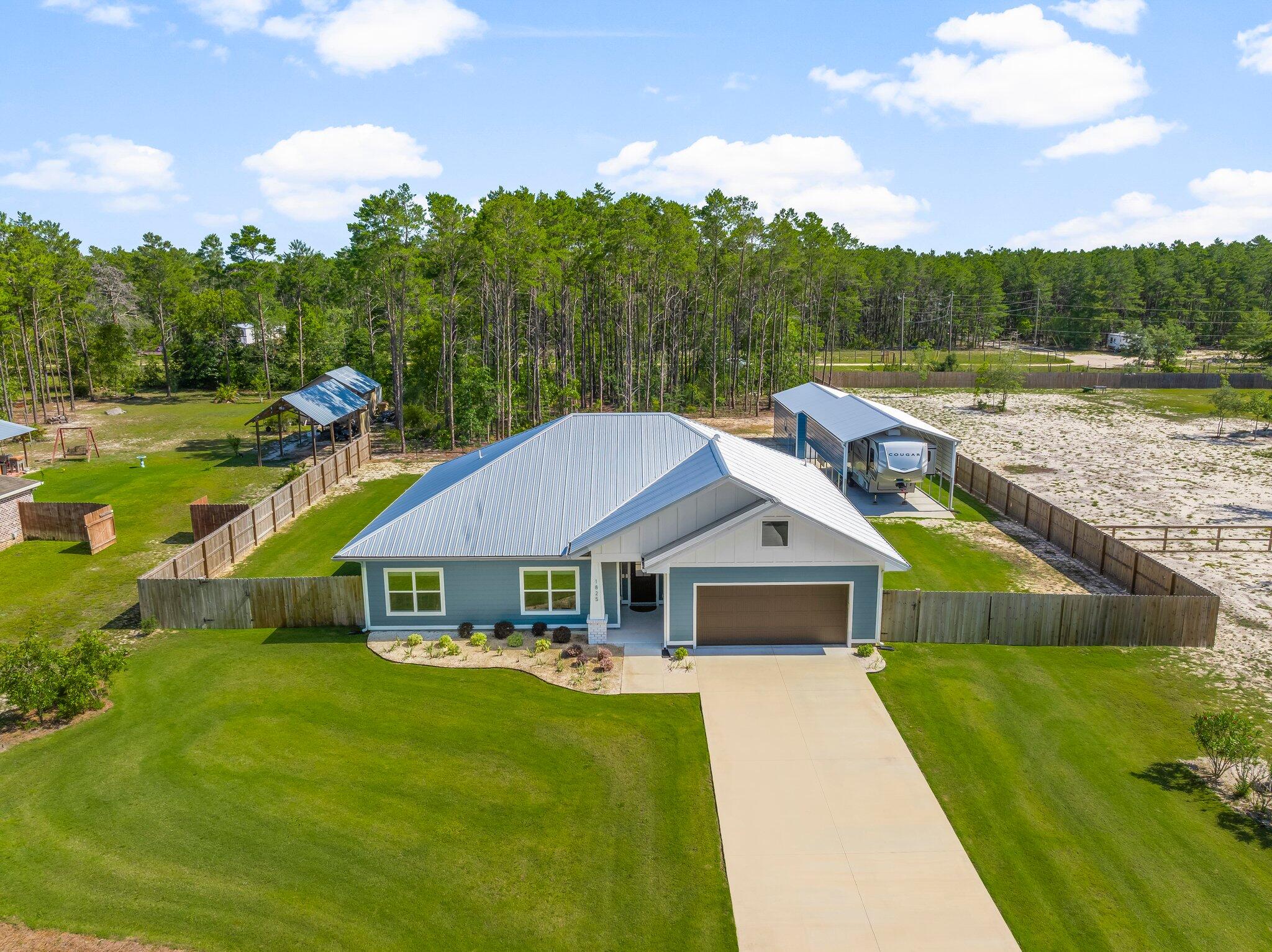 Check out the brand-new photos for this FANTASTIC HOME! Built as the Scholarship Home with amazing extra features, it is easy to ''Accentuate the Positive'' when there are no negatives! This is a 2023 Bay County Parade of Homes MODEL HOME that you are sure to cherish. Built on almost an acre, you will love the quiet neighborhood and the efficiency of this home. Your monthly expenses will be low because of the foam insulation everywhere, including over the garage. There will be no water or sewer bills because of the newer well and septic system. Homeowner insurance currently costs less than $200 monthly for a very good policy with State Farm. The sprinkler system runs on the well, and you will be happy to know that flood insurance is not required. There is no Association fee, -(See More.) but the address is in a very popular location for desired schools. The home itself has soft close cabinets, upgraded toilets, heated mirrors in the Master Bath, upgraded lighting, energy efficient windows, hard surface countertops, great appliances and a beautiful metal roof. In the spring, the Golf Course style Bermuda grass will be a gorgeous color to behold. You will need to check out all the extras the owners have included. In addition to spending thousands of dollars to cut down some trees, they added a fenced-in area for the dogs. They also added a workshop and an RV barn. They built an enclosed screened room measuring 23 x 31.5 with a concrete floor where they enjoy sitting in a bug free area to watch the deer at the back of their property. Add a few thousand dollars more for a generator plug, additional sprinklers, and gutters on the 18 x 30 shop. The RV carport is 14 feet tall and measures 18 x 35. All told, the amount is an impressive extra $75k in improvements-- and you can enjoy it immediately without lifting a finger. Too beautiful to miss, don't lose this opportunity before someone beats you to it!