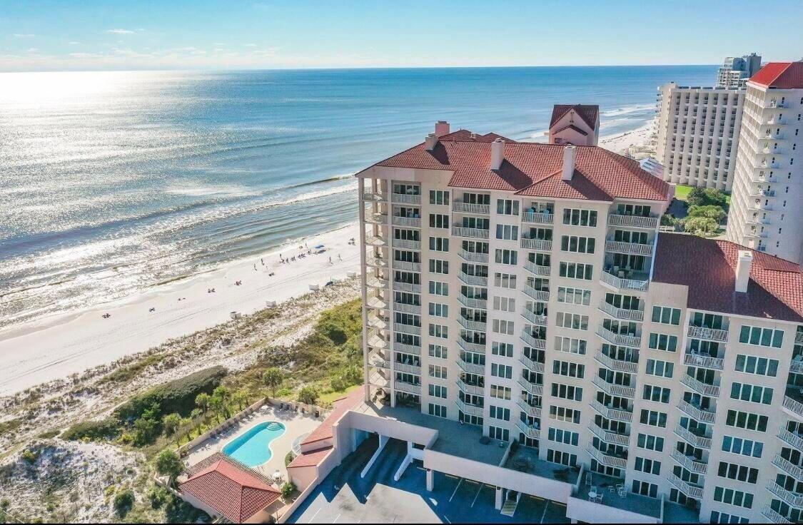 Step into your dream retreat with this beautifully appointed ground floor unit, just steps from the beautiful beaches. This coastal haven offers the perfect blend of comfort, style, and convenience, ideal for beach lovers and those seeking relaxation. Inside, you'll find an open-concept layout filled with natural light, featuring modern furnishings, soft neutral tones, and tasteful coastal accents. Large sliding glass doors lead directly to a patio where you are steps away from the beach and the community pool--just a short walk from your front door. No elevators or long walks required--everything you need for the perfect beachside getaway is within reach.