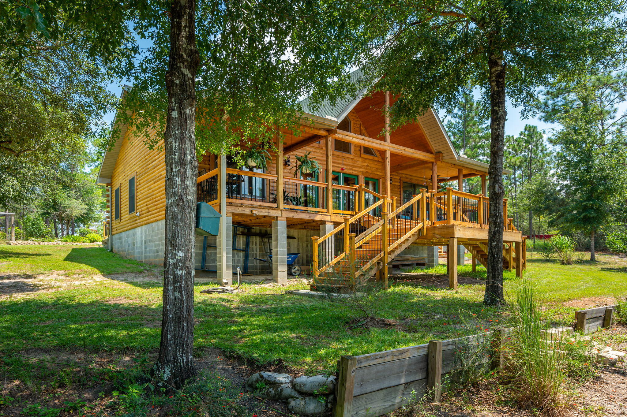 It feels like Tennessee only better, it is in FLORIDA! This log cabin sits on over three acres with approximately 300 ft of waterfront. It features a giant back porch which beckons for morning coffee & wildlife viewing! Inside, the open layout includes a great room with cathedral ceilings and natural light through out, a kitchen with breakfast bar, dining area and loft space. To the left of the great room is the master bedroom suite overlooking Quail Lake & the two car garage. To the right, is your office (easily converted to a third bedroom), utility room with tons of cabinet space and sink, additional bathroom and your second bedroom also overlooking the water. Plus outside is the spacious dock, 11x20 workshop and greenhouse!