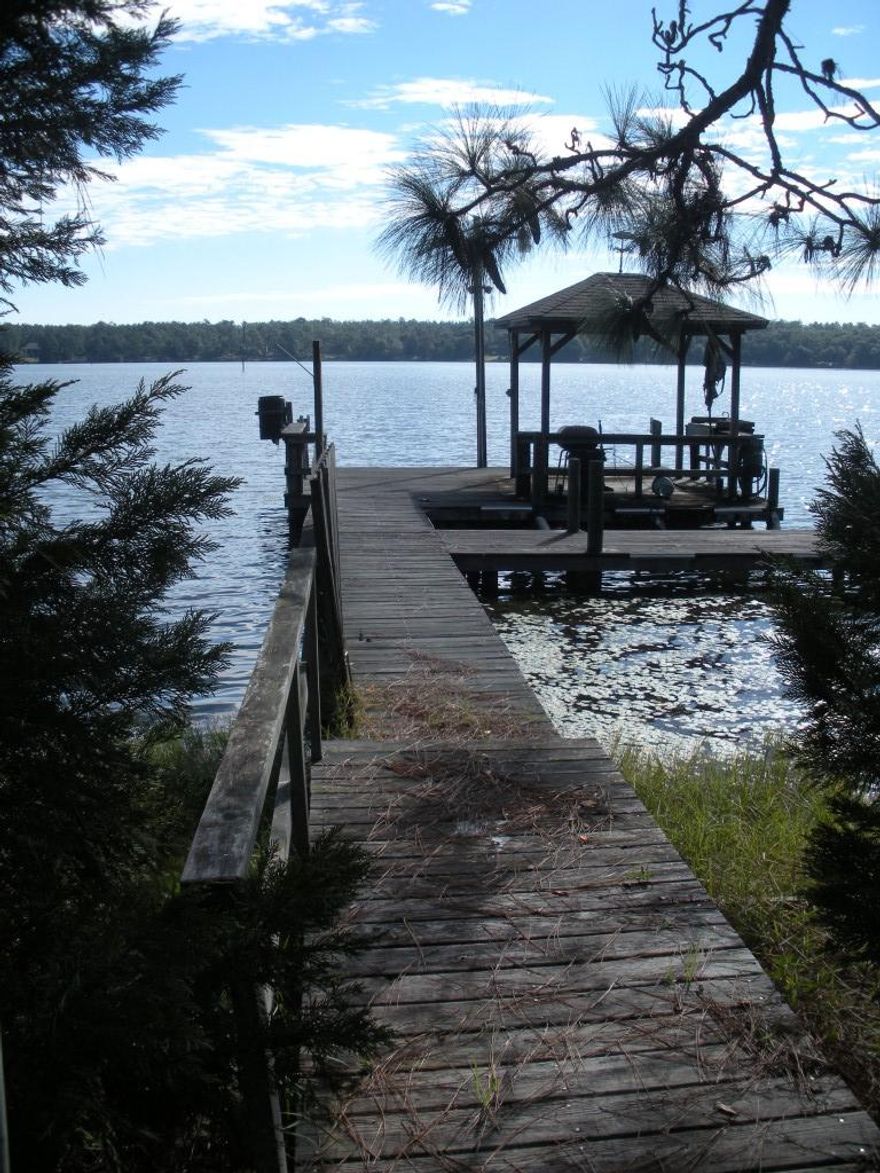 Modern lakefront home with brand new HVAC system on about 2.61 acres awaits you! This all-brick 3 bedroom, 2 bath home with split bedroom plan sprawls on tranquil Spring Lake with 225 ft on the lake itself! This is more access to the lake than most of the 1 acre lots! Your side entry garage, oversized 2 car garage, and extended driveway gives the home great curb appeal and will allow many guests to visit you! The peace and quiet hear will disarm you! The awesome wide tiled entry offers pillars and a lovely access to the great room with 12 ft ceilings, wood burning fireplace, and decorative shelving. The office could easily be converted to a 4th bedroom, if you feel the need, or keep it as an office / reading room. Call for your appointment today! For more information, click ''More''