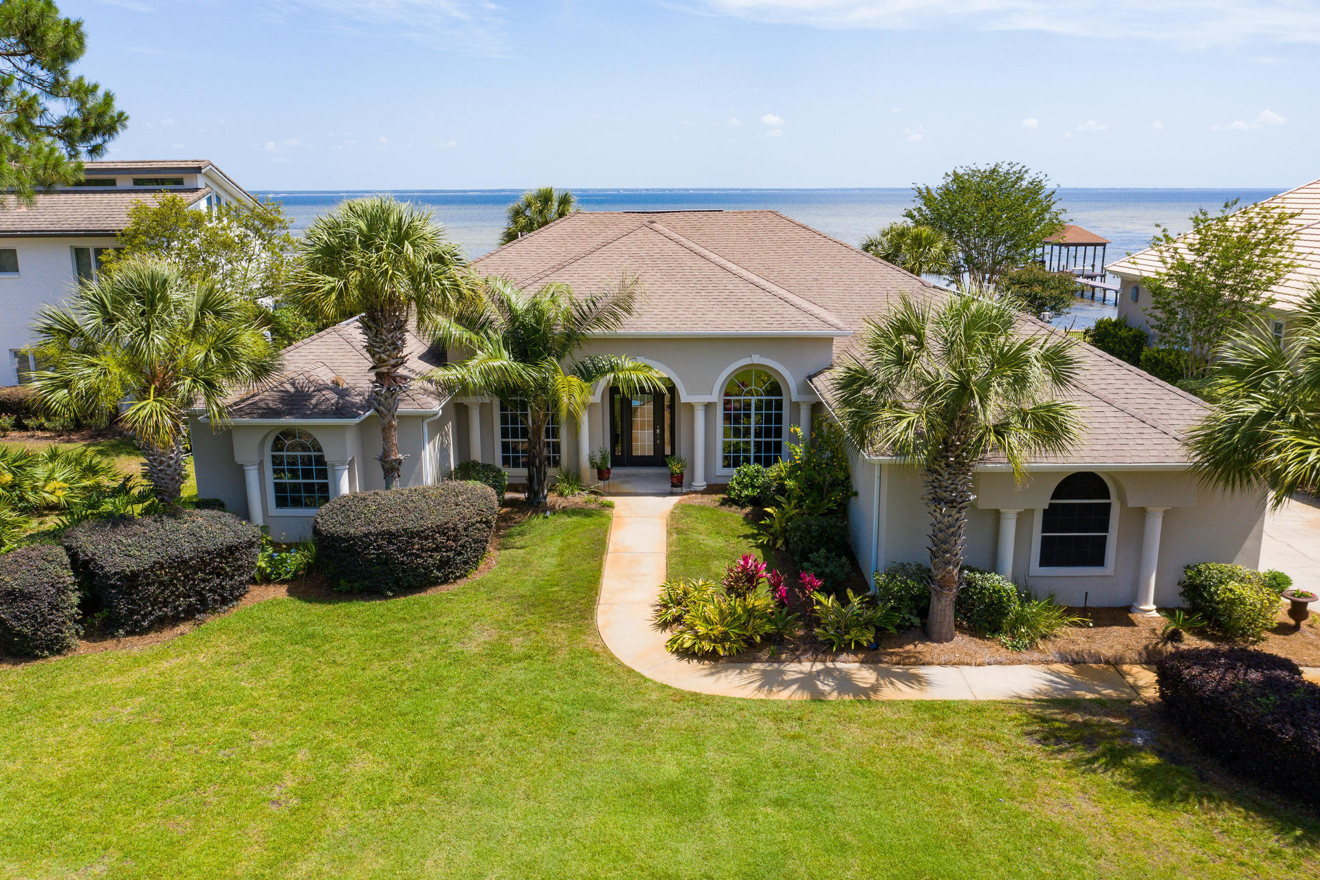 An incredible home in the ideal location. This beautifully renovated home is move-in ready. With new custom kitchen, three remodeled full baths, rebuilt pool, dock, lanai and more, you won't have to do a thing. Except maybe pull up a chair on one of the largest private docks on the bay and enjoy your view of sunrise or sunset. The entire rear of the house has unobstructed views of the bay, and of the almost 2000 SF outdoor living area. A newly redesigned saltwater pool centers the lanai, with multiple seating and dining areas. Inside you will find a kitchen designed for efficiency and style, with views of the pool and bay. The huge MBR has bay views, and the ensuite bath features custom shower, soaker tub, double vanities, and even a bidet. Plus, the beach is only a mile away!