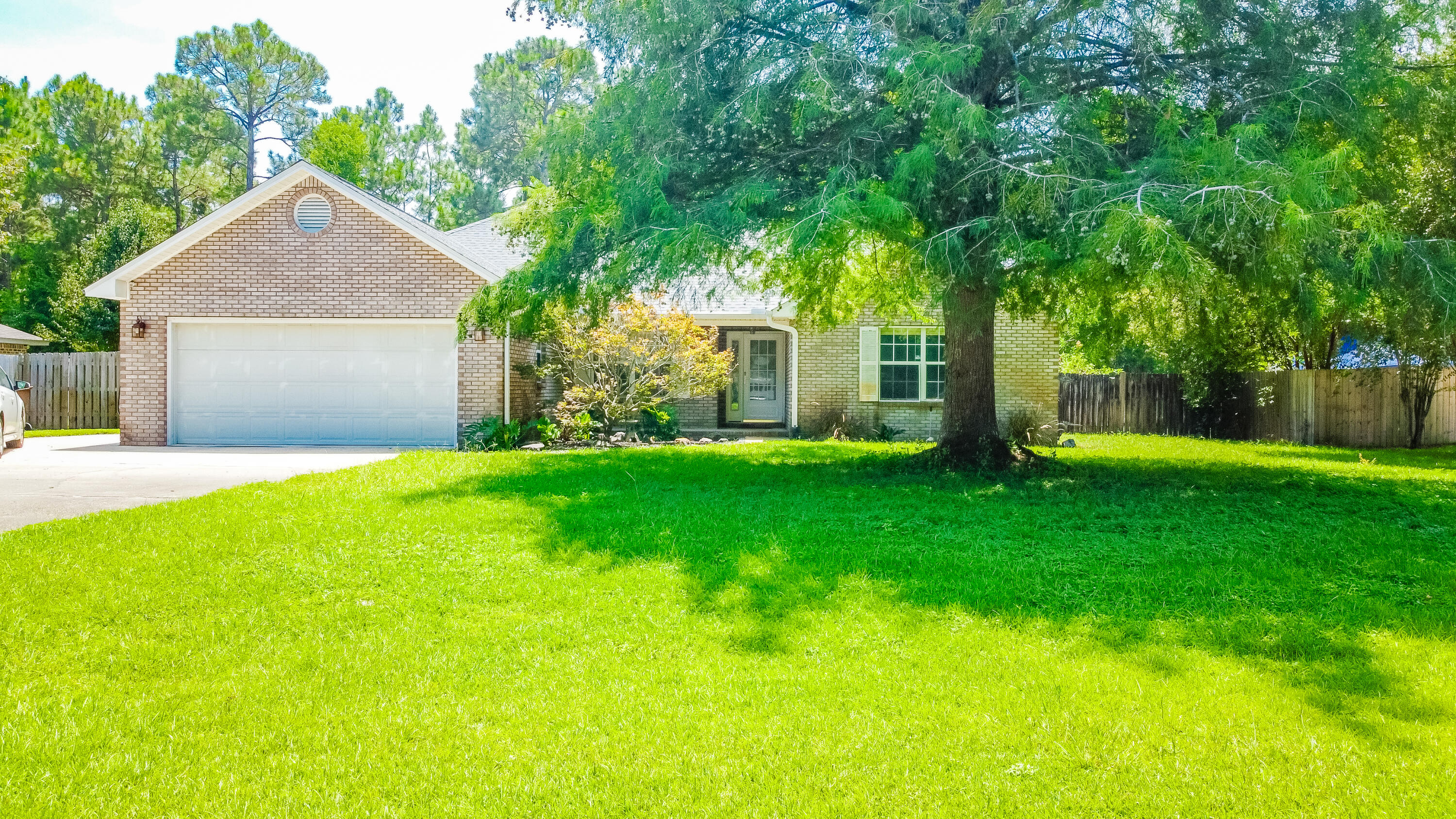 Beautiful home with several upgrades in Navarre! Located in Holley By The Sea, the property features a newer roof (2023), solar panels, updated HVAC (2020) & hot water heater. The exterior showcases a fenced backyard with several fruit trees, sprinkler system, yard building & an open patio area that is just outside the spacious sun room. The interior includes vaulted ceilings, updated flooring in living areas, & remodeled bathrooms. The owner's suite includes plenty of natural light, a sitting area, & an updated bathroom with a walk-in shower, granite countertops & custom cabinetry. Enjoy access to the community recreation center's amenities including swimming pools, tennis & basketball courts. The property is located within 6 miles of Navarre Beach & within 15 miles of Hurlburt Field.