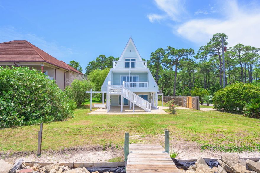 SELLING 2 PARCELS TOGETHER 29-2S-28-0000-01002-0000 & 20-2S-28-0000-00500-0000. Projected rental income of over $50,000 annually! This one-of-a-kind A-frame waterfront retreat offers an incredible opportunity for homeowners, investors, or those seeking a versatile vacation home. With $20K+ in rental projections for the private studio on the first floor with its own separate entrance (506 sq ft). An additional $33K projected for the main house (2nd & 3rd Floor...1008 sq ft). Nestled at the end of a dead-end street, this 3-story home sits on a spacious 0.8-acre corner lot along the tranquil shores of East Bay. Its unique architecture, fresh interior and exterior paint, new roof and combined with stunning water views and a private (NEW) dock, creates a serene coastal escape like no other! T he ground level features a studio with a private entranceperfect for rental income, guests, or multigenerational living. The studio offers water views, a kitchenette, a full bathroom with a large vanity and walk-in shower, and direct access to a large covered patio overlooking the bay. Upstairs on the second floor, the main living area features a kitchen with stainless steel appliances, butcher block countertops, and a stylish white tile backsplash. The living room is filled with natural light thanks to expansive sliding glass doors that frame the water and lead to a covered balconyideal for outdoor dining or simply enjoying the view! This level also includes a bedroom and full bathroom. The third floor is home to the primary bedroom suite, which boasts water views galore and private balcony access through large sliding glass doors. A second bedroom sits at the opposite end of the floor, with a full bathroom located between them. Enjoy outdoor living at its finest with multiple decks and balconies, a private dock for fishing or kayaking, and a generous yardperfect for gardening, kids, or pets. Located just off Highway 98 and minutes from Pensacola Beach!