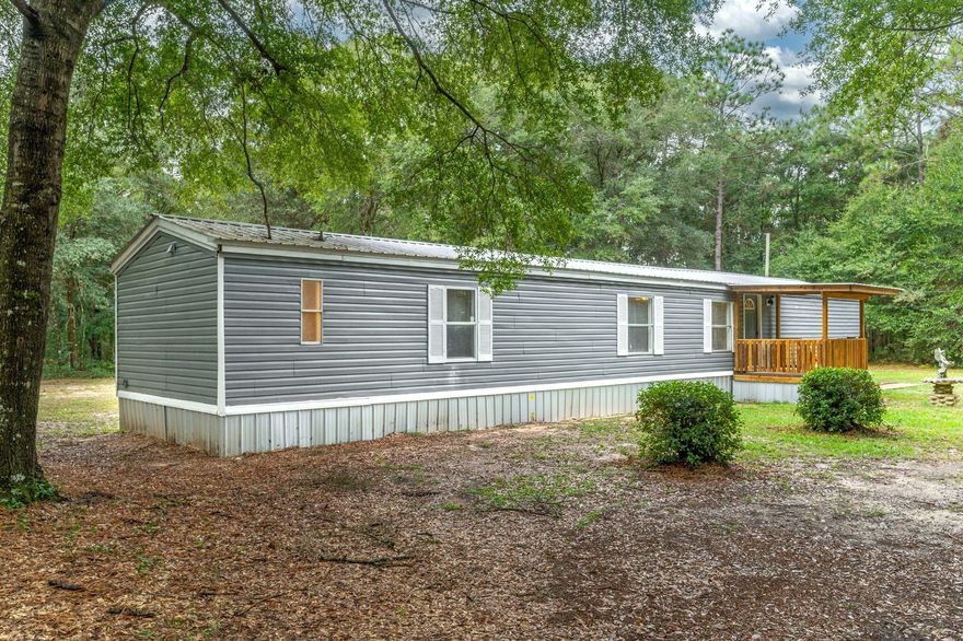 Escape to the peace and quiet of country living on nearly 2.5 serene acres, surrounded by mature trees offering a semi-private, park-like setting. This beautifully updated manufactured home is move-in ready, featuring fresh paint throughout, brand-new flooring, updated windows, and more. Whether you're looking for a quiet retreat, space to garden, or room for your animals and hobbies, this property offers a perfect blend of comfort, privacy, and nature.