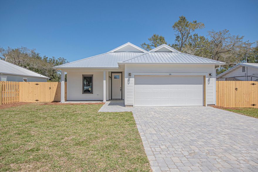 Step into this semi-custom home beautifully designed with plenty of upgrades. Let's start outside. This home greets you with hardi siding, impact windows and doors, metal roof (all for discounted insurance rates), cornered back patio, sodded yard with irrigation, privacy fenced back yard, and paver driveway round out the outside. As for the inside, let's start with the kitchen, white shaker style cabinets with crown molding, built-in microwave in island, a gas stove with stainless steel vent hood (venting to the outside), full-size refrigerator with water & ice in the door, dishwasher, garbage disposal, all under gorgeous quartz countertops. Moving on, all 8 foot doors and  plank vinyl flooring throughout the home as well as 9/10 foot ceilings. Plenty of can lights as well as upgraded light fixtures. The living room features a tray ceiling and an electric fireplace, Now for the master bedroom, which features its own tray ceiling with fan and can lights. Master bath has a double bowl vanity with quartz top. Master shower is 4'x5', tiled with bench to relax on. All closets and pantry have wood shelving. Energy wise, the home features all spray foam in walls and attic, and a gas tankless water heater providing endless hot water. Home is 2 minutes to Tyndall Air Force Base, 3 minutes to Bay Oaks Park (a beautiful park on the bay), and 5 minutes to shopping. Put this home on your short list.