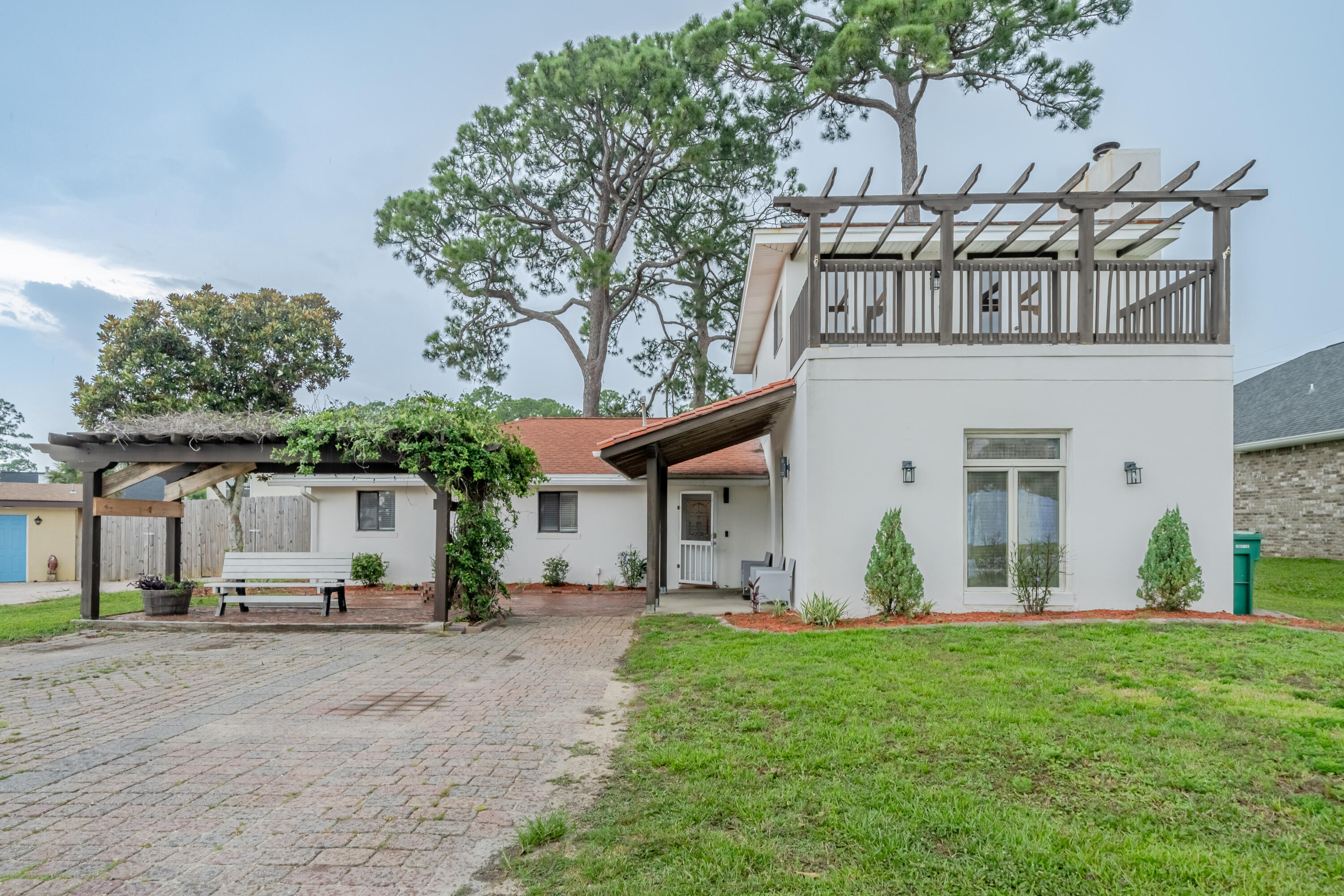 Step into the charm of this recently remodeled Spanish-style Mediterranean home, where rustic and contemporary styles blend seamlessly. A welcoming brick courtyard offers serene water views and a pergola for shaded relaxation. The spacious living room boasts high wood beam ceilings and a cozy fireplace, creating the perfect ambiance for a home theater or library. Ascend the spiral iron staircase to discover the master suite, which occupies the entire second floor and provides breathtaking water views of the sound. The master bath indulges with a generous whirlpool tub and a staircase leading to the backyard, featuring a brick-laid path and two substantial sheds.Sheds, measuring 10'x20' and 20'x20'. The larger of these buildings is equipped with electricity, water, a laundry room, a