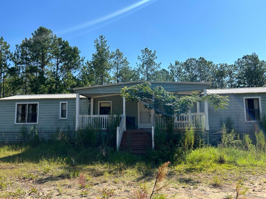 Affordable mobile home located on outskirts of Ponce de leon in Holmes county.  This mobile home could be brought back to life with some elbow grease.  It has good bones including original exterior walls being replaced with Hardi Board, both bathrooms have been tiled, floors are solid. Split bedroom plan both having walk in closets.  Large covered porches on front and back. Back porch screened. Metal 2 car carport plus two other exterior buildings.  Well water and septic.  Stainless steel fridge and stove, stackable washer/dryer.  HVAC is 7 ton.