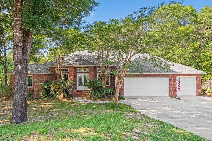 This exquisite property in Rocky Bayou Estates, built by Randy Wise in 2000, epitomizes elegance and durable craftsmanship. Boasting 4 bedrooms 3 bathrooms, this home is perfectly positioned on a serene cul-de-sac , allowing for a peaceful living environment while being conveniently located near all that Niceville has to offer. As you enter the home, you are greeted by a spacious floor plan designed to maximize comfort and privacy. The heart of the home is the chef's kitchen adjacent to the living area to create an open style setting. Generous counter space and custom cabinetry make it ideal for entertaining guests or enjoying intimate family gatherings. The builder was thoughtful on every detail as this served as his home before the current owners. The one story layout and split bedroom plan give the parents their own private serene setting while the additional bedrooms allow the children or guests their own private space. All the bedrooms have fresh paint done right before listing. Laundry room is situated just as you enter from the garage and close to the primary bedroom. The primary suite and bathroom are very impressive with separate shower and freestanding tub with a large picture window overlooking the gorgeous backyard. His and her walk in closets and ample counter space with double vanities. The home has so many features it is important to see for yourself as this description cannot do it justice. Lets start with All brick exterior, New Windows with a lifetime warranty transferable (2021), roof (2021), covered front and rear entry, office, New GE stainless steel appliances, golf cart garage, sink in laundry room, mud room, hardwood floors, raised ceiling, crown molding, built-in bookcases, plantation shutters, fireplace, new paint, cabinet lighting, recessed lighting, pantry, breakfast bar, breakfast nook, foyer, bonus living area and so much more. The backyard of this home is truly a paradise, offering a unique experience akin to living in your own personal treehouse. The elevated deck provides a serene vantage point, allowing you to immerse yourself in the tranquil beauty of the surrounding wooded area and the perfect backdrop for relaxation and connection to nature. The outdoor experience continues with a stunning gunite swimming pool and over 1200 sqft of decking that the family will enjoy. 3 car garage with attic storage space and utility room with even more storage space. With its superb design and prime location, this home truly represents a remarkable opportunity for the next family looking to share wonderful memories of their own.