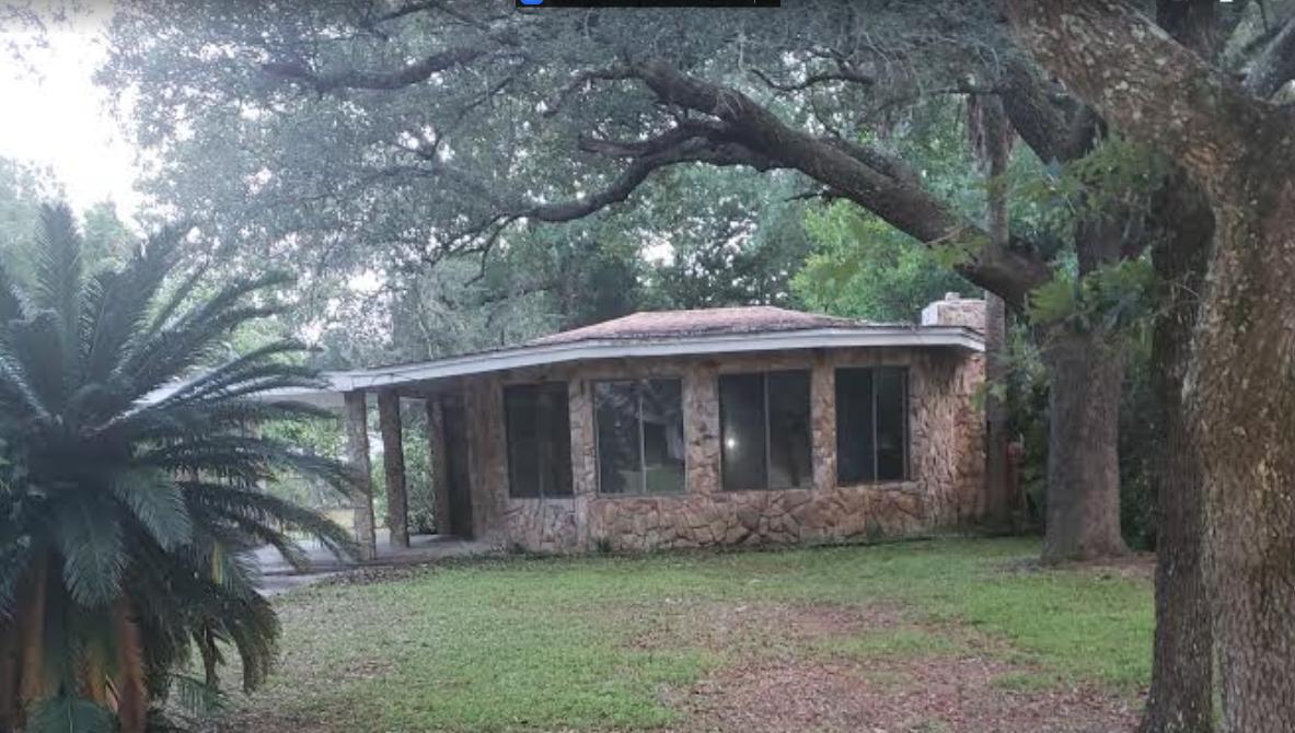 Florida style cottage home. Home features a stone fireplace in the living room, with the kitchen overlooking the living room and dining room. Two bedroom- one with built in storage/shelving area. Large utility room. 1 1/2 bath with a jacuzzi tub. Nice size lot with large trees and mature landscaping. Home is sold AS-IS - CASH Only Buyers. Proof funds must accompany all offers.