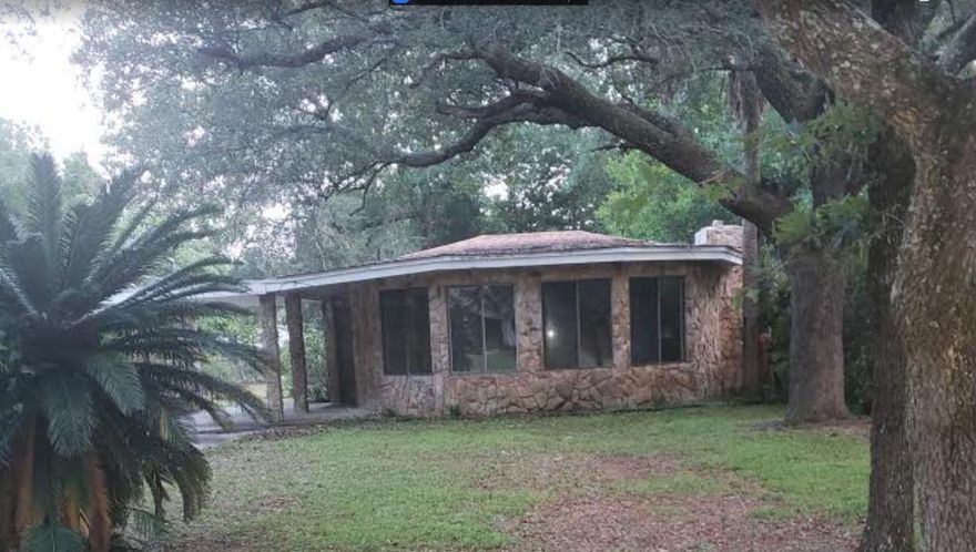 Florida style cottage home. Home features a stone fireplace in the living room, with the kitchen overlooking the living room and dining room. Two bedroom- one with built in storage/shelving area. Large utility room. 1 1/2 bath with a jacuzzi tub.  Nice size lot with large trees and mature landscaping.  Home is sold AS-IS - CASH Only Buyers.  Proof funds must accompany all offers.