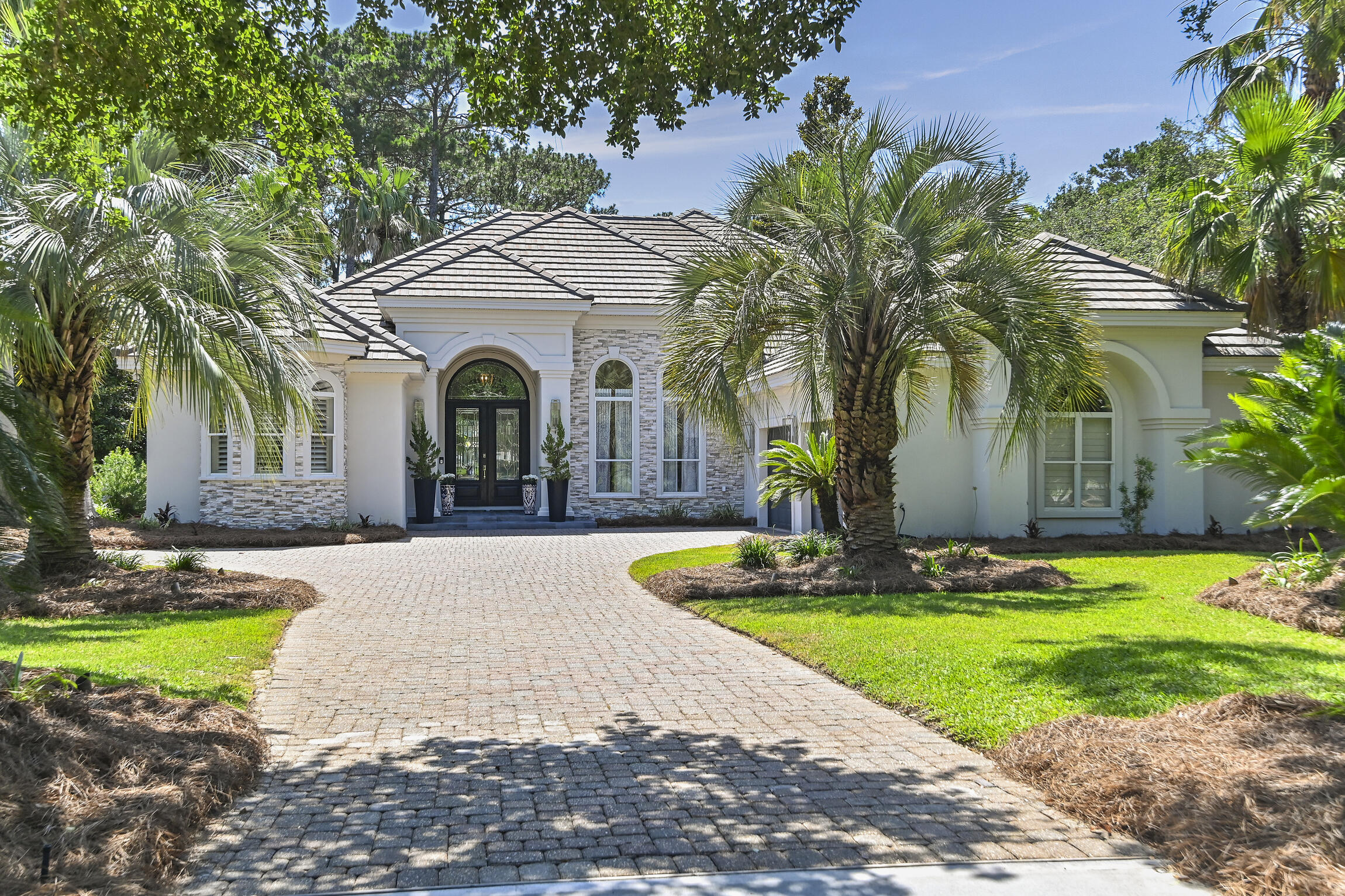 Welcome to your new paradise nestled along the 7th and 11th fairways of the Fred Couples designed Kelly Plantation Golf Course! This stunning 4-bedroom, 4-bath home is the epitome of elegance and comfort. Step inside and prepare to be amazed. With travertine flooring throughout, this open-concept home boasts a seamless flow from room to room. The updated kitchen is a chef's dream, featuring top-of-the-line appliances, sleek countertops, and modern fixtures. But that's just the beginning. Picture yourself relaxing by the pool, surrounded by majestic oak trees and lush landscaping. The screened enclosure allows you to bring the outdoors in for full enjoyment of your outdoor oasis, complete with an outdoor kitchen perfect for entertaining guests on warm summer evenings.
