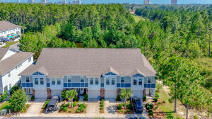 Hot tub conveys with this spacious townhome. Custom built-in storage in pantry and master closet plus storage under the stairwell and in the attic. Downstairs has 1/2 bath, 10 ft ceilings and all LPV for beach living. All 3 bedrooms are upstairs as are 2 full baths. Master bedroom with vaulted ceilings has a pond view and 480 acres of woods. The backyard is perfect for grilling, birdwatching or relaxing in hot tub. Nearby additional parking is easily accessible to the backyard and patio. All this and just a short distance (with sidewalk access) to the community pool and community center. HOA includes yard maintenance, structure and flood insurance, trash services, use of community amenities and plenty of green spaces. Well maintained and conveniently located