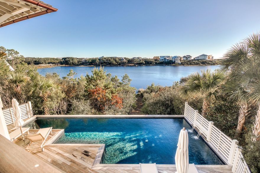 This masterpiece is a rare opportunity in WaterSound Beach. Located directly on Camp Creek Lake, the private outside retreat is unparalleled in size with an enormous heated pool, sun deck & oversized screened porch with numerous spaces to enjoy the Lake & Gulf of Mexico views. The manicured courtyard includes a water feature & an old Chicago brick sitting area that leads to a residence that encompasses extraordinary finishes & impressive attention to detail. The master bedroom exudes coastal elegance & includes multiple closets & a bath retreat with soaking tub, separate shower & Waterworks tile & faucets. There are two additional guest bedrooms & ensuites with a calming coastal palette, laundry, garage & large storage area that complete the first level. Heading up the staircase one notices the natural cypress shiplap walls & ceilings & Ferrante chandelier.  The open & fluid living & dining room are accentuated by a vaulted ceiling & custom concrete fireplace. An abundance of light streams through the multitude of windows & doors showcasing the spectacular water views.  The large & inviting gourmet kitchen has all of the highest end accoutrements including Wolf, Subzero & Bosch appliances, marble countertops & a handmade backsplash from Waterworks. There is also a cozy den with built-in cabinets, additional guest bedroom with ensuite & private porch & powder bath.   The crown jewel is the second floor covered porch which allows for panoramic Camp Creek Lake & Gulf of Mexico vistas.   There is plenty of space to enjoy the incredible sunsets in the multitude of seating areas.  Other interior selections include Weather Shield windows & doors, solid walnut & marble flooring, Brazilian hardwood decking & custom millwork.  There is an elevator shaft that is currently a closet on each floor that could easily be transformed into an elevator. This home, perfectly blending form & function, with a masterful use of timeless lighting, stunning features, fixtures & pride of craftsmanship will leave a lasting impression!