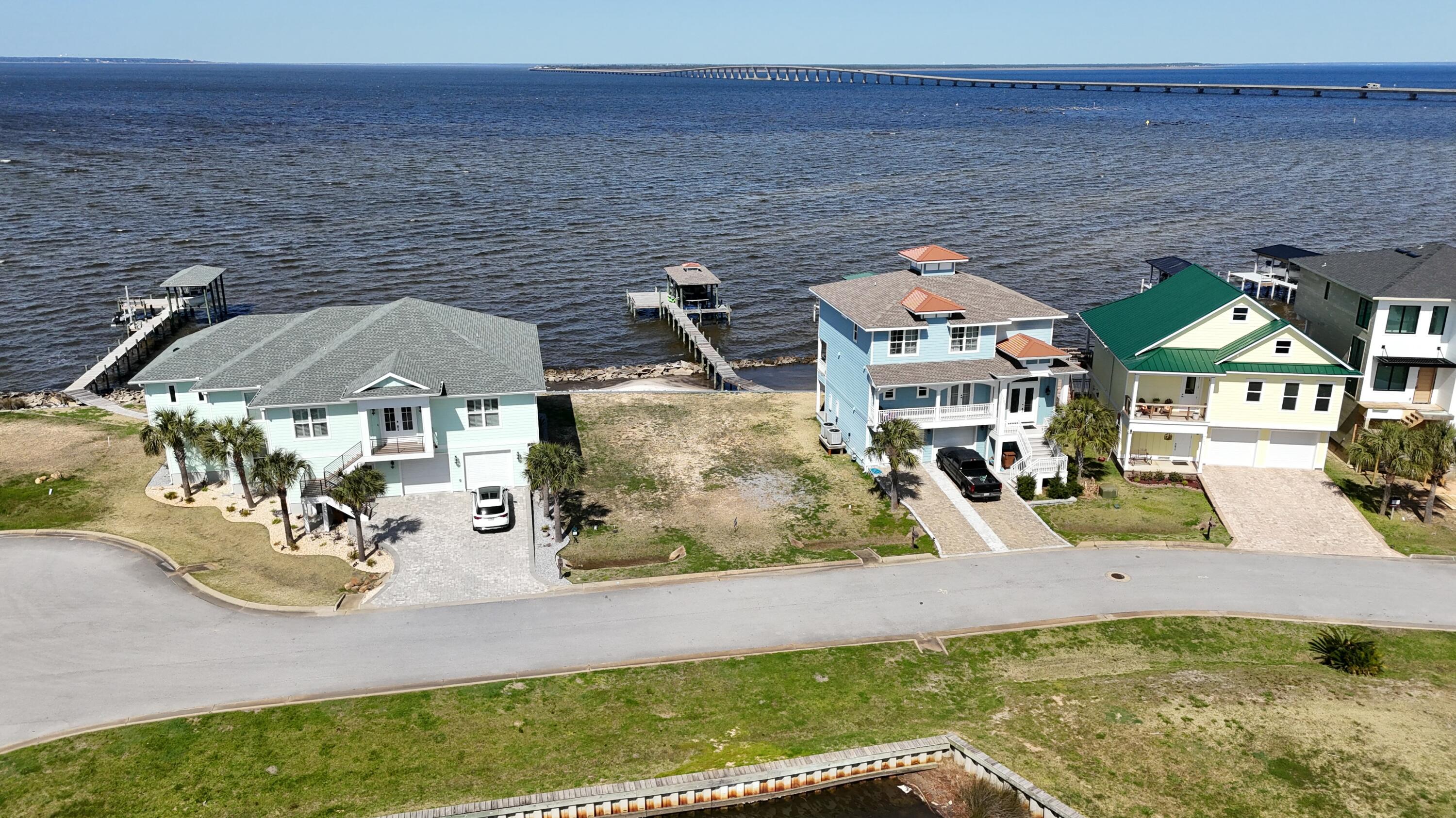 Here's your chance to build your dream home on the water with over 60 feet of waterfront! This small and quiet gated community of Clipper Bay is a hidden jewel in this area of Gulf Breeze. Located at Redfish Point with captivating views of the Bay, including Garcon Point Bridge and Three Mile Bridge. This improved lot is ready to go with water connection, sewer tap & power.