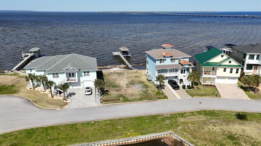 Here's your chance to build your dream home on the water with over 60 feet of waterfront! This small and quiet gated community of Clipper Bay is a hidden jewel in this area of Gulf Breeze. Located at Redfish Point with captivating views of the Bay, including Garcon Point Bridge and Three Mile Bridge. This improved lot is ready to go with water connection, sewer tap & power.