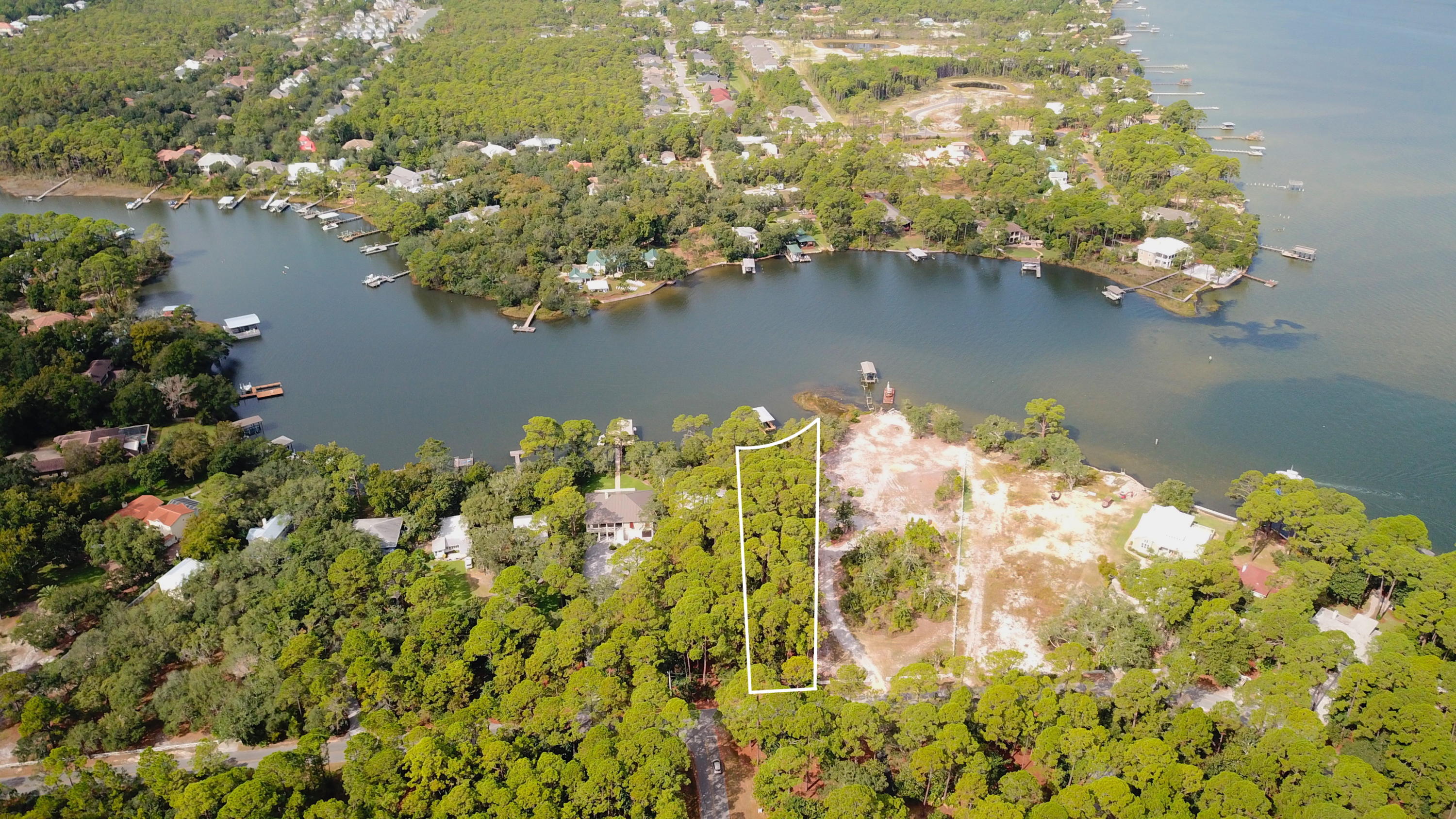 This deep water bayou front lot in Santa Rosa Beach offers approximately 100 feet of prime water frontage along Hewett Bayou. Covering just over three quarters of an acre it offers direct access to Choctawhatchee Bay and the Gulf of Mexico beyond. The lot offers a newly built dock with boathouse and boat lift.